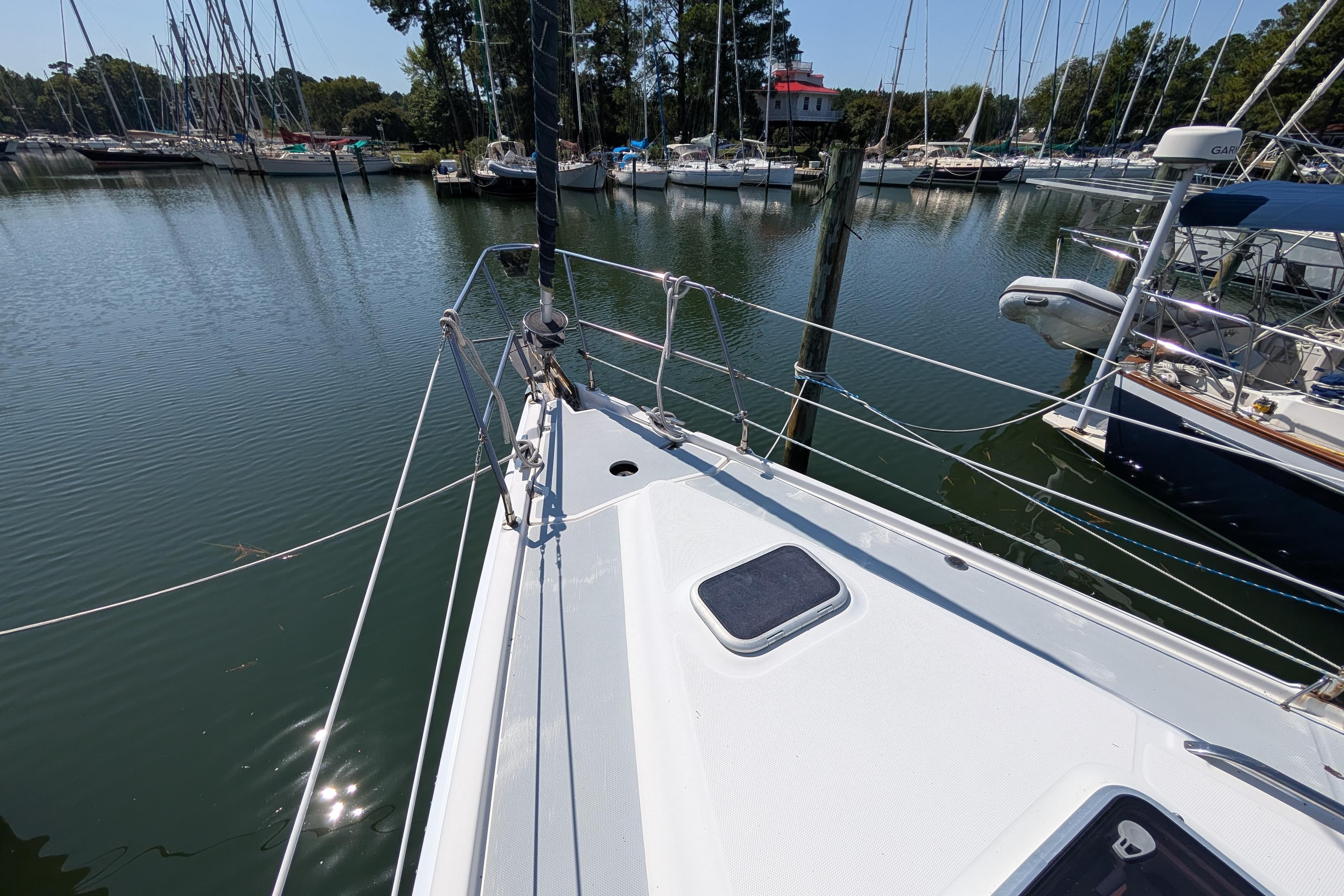 Bow of 2002 Hunter 410 sailboat docked in a marina with surrounding boats.