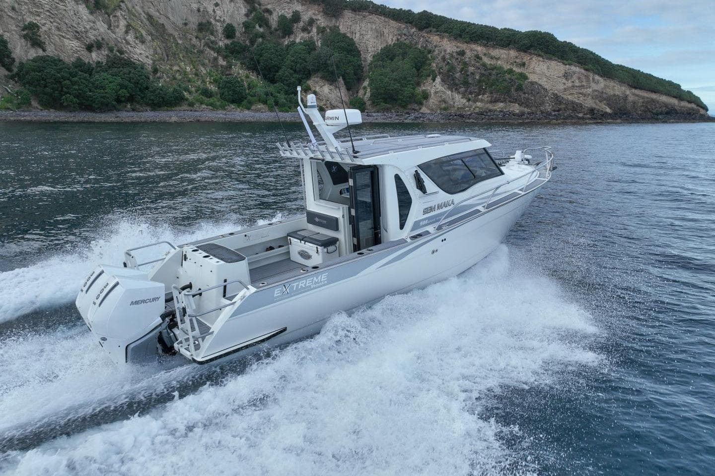 2026 Extreme Boats 986 Game King cruising on water near rocky coastline.