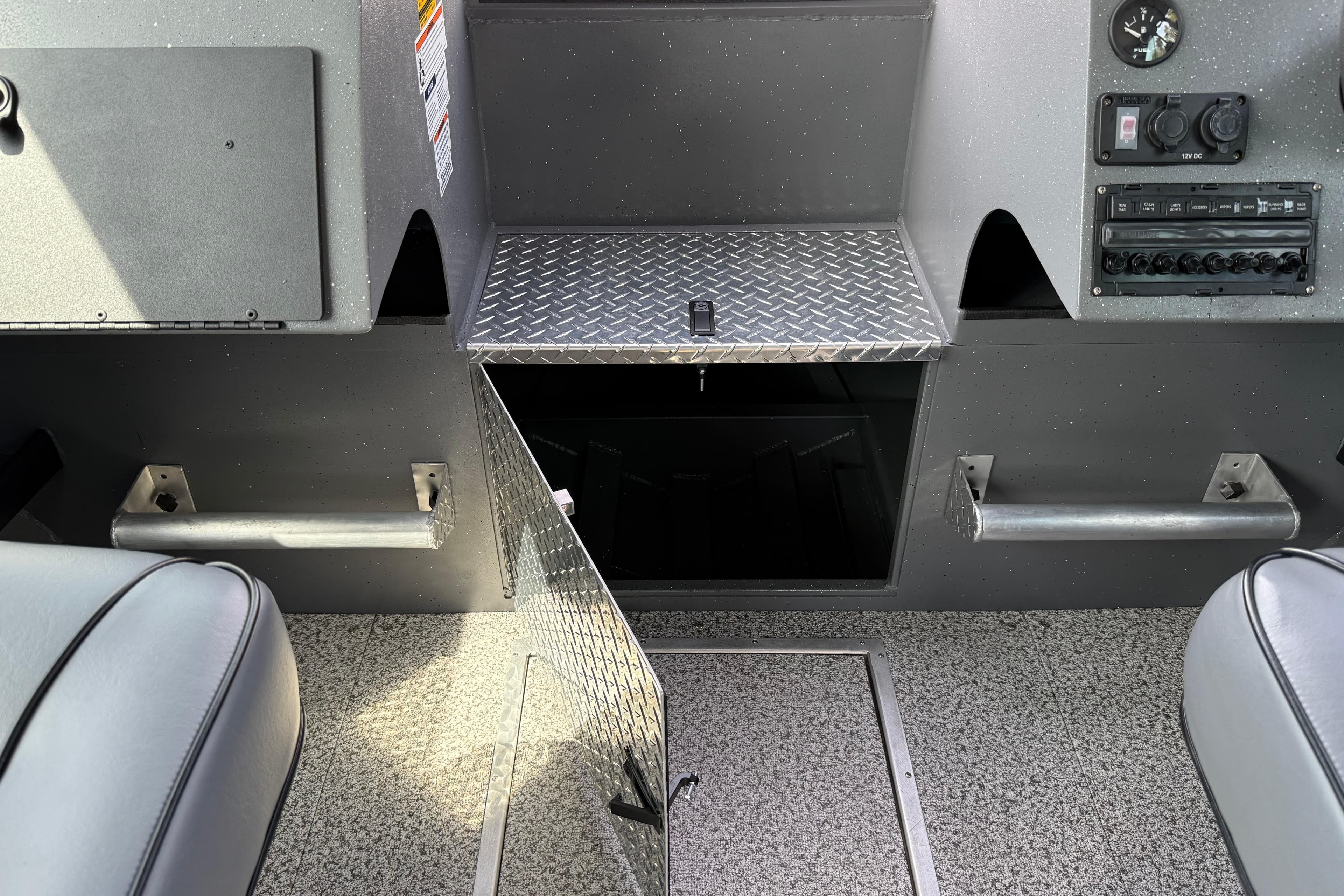 Interior of 2026 Alumaweld Horizon 26 boat with open storage compartment and control panel.
