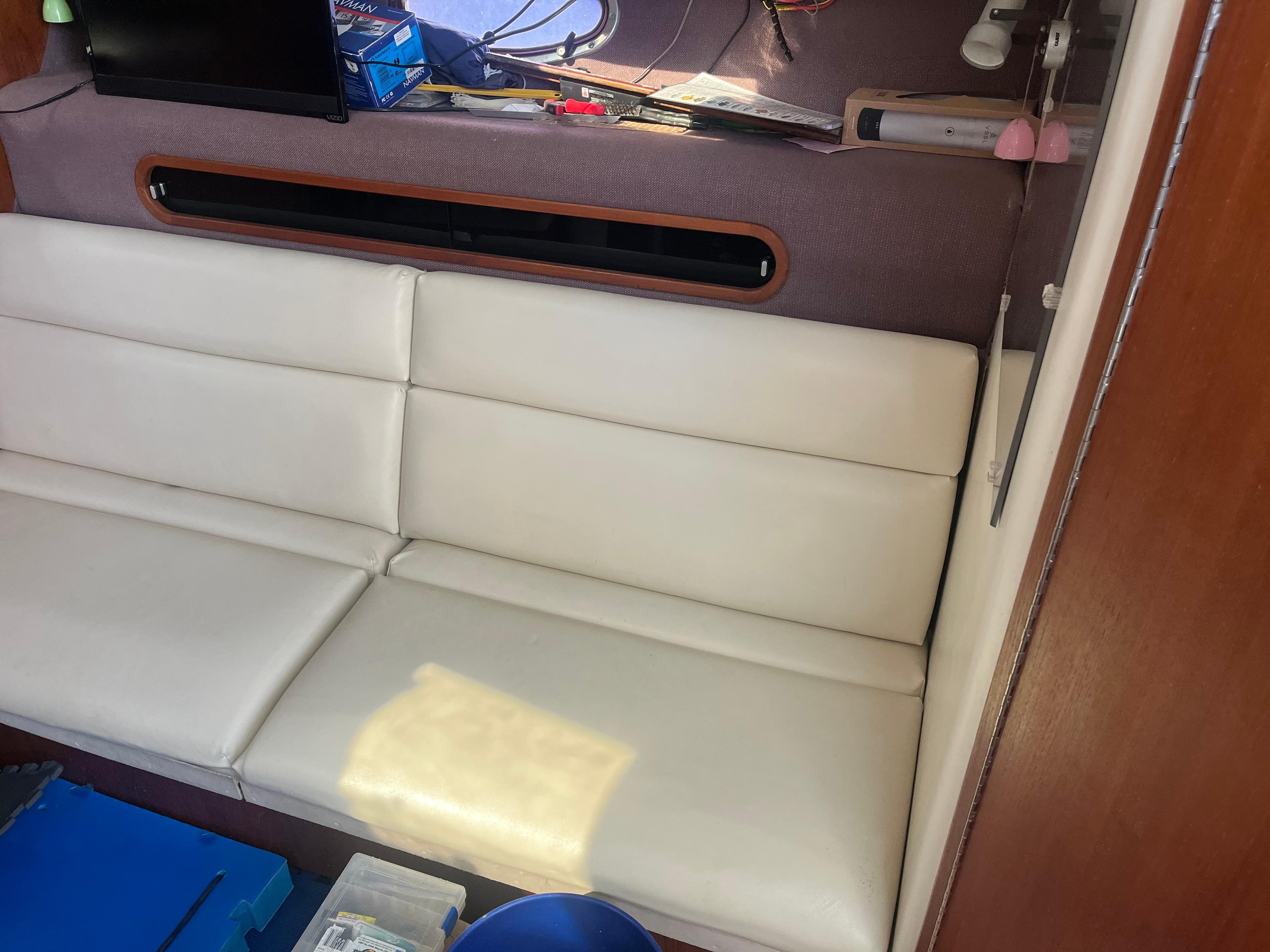 Interior of 1989 Tiara Yachts 33OPEN with white leather seating and storage area.