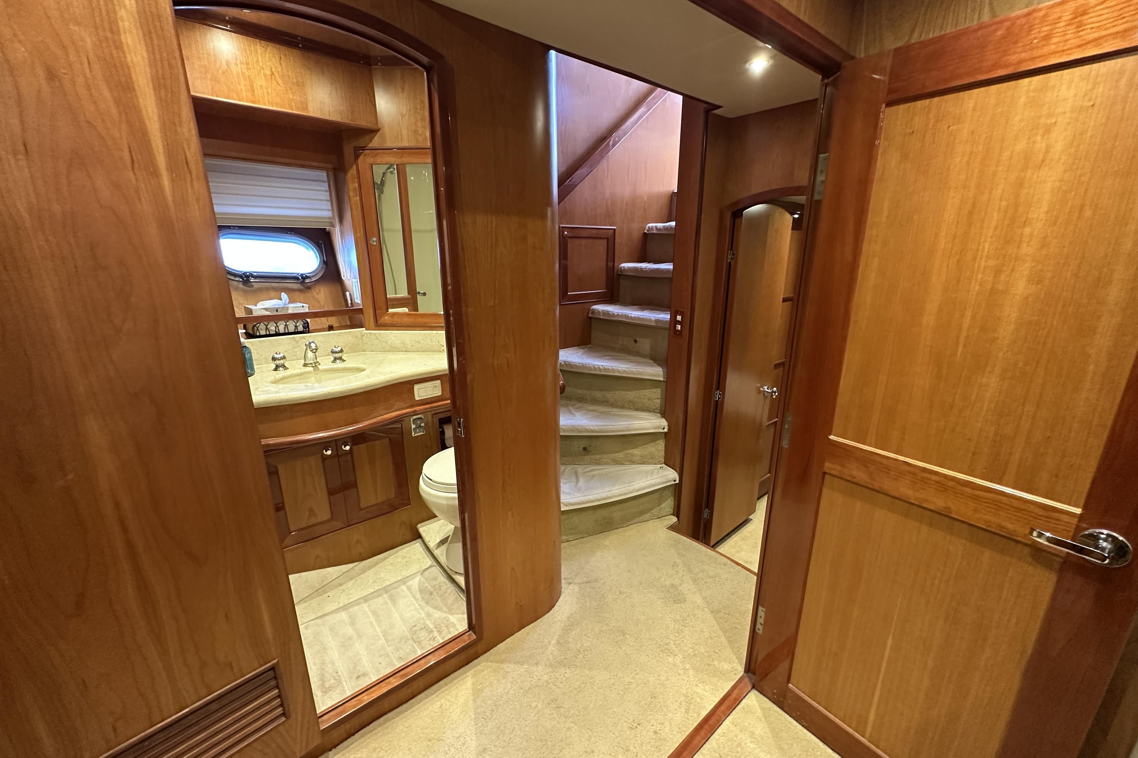Interior of 2004 McKinna 57 PHMY yacht with wooden finishes and staircase.