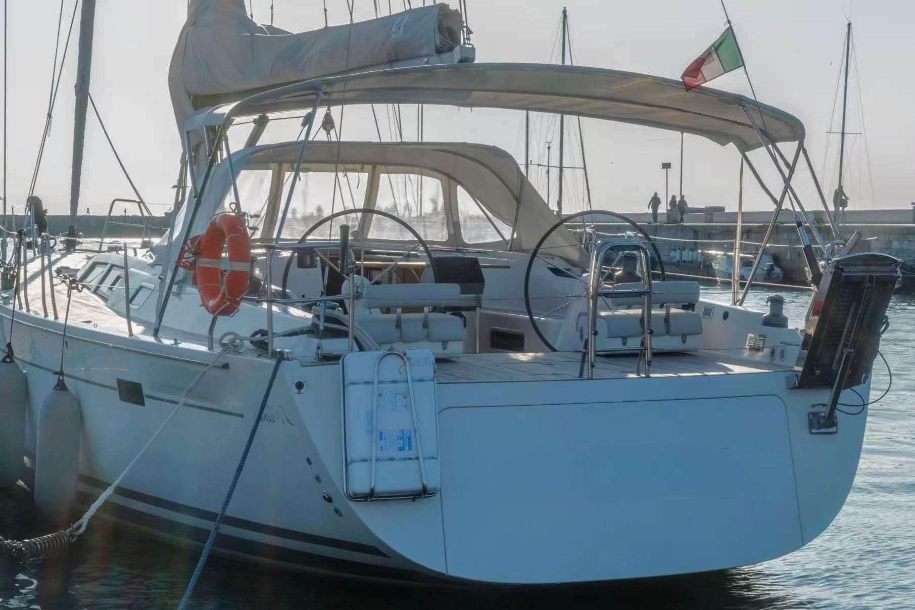 2007 Hanse 540e yacht docked in marina, featuring dual steering wheels and sunshade.
