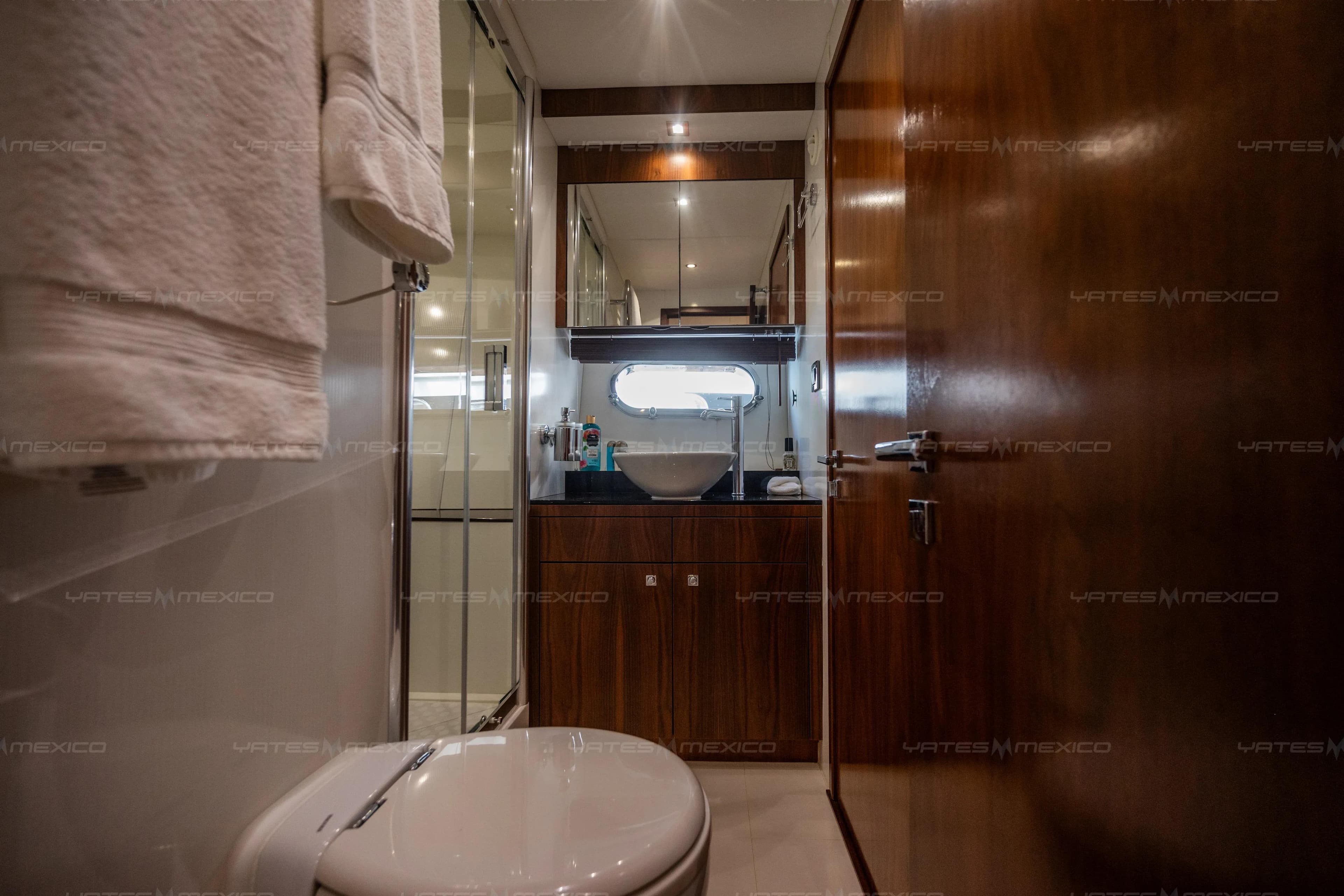 Luxurious bathroom interior of 2015 Sunseeker 75 Yacht with modern fixtures and wooden accents.