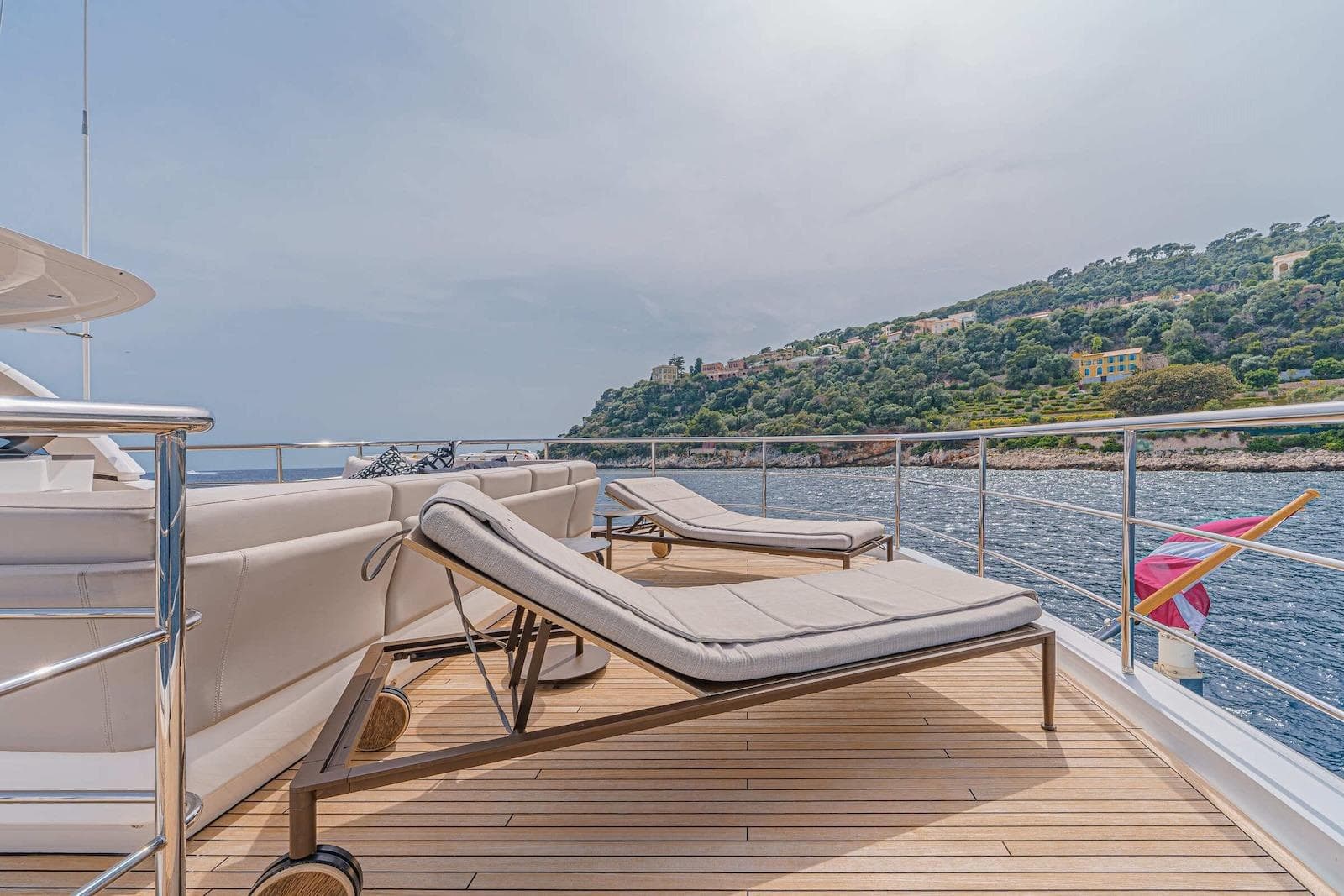 Luxurious 2018 Princess 35M yacht deck with sun loungers, overlooking scenic coastal view.