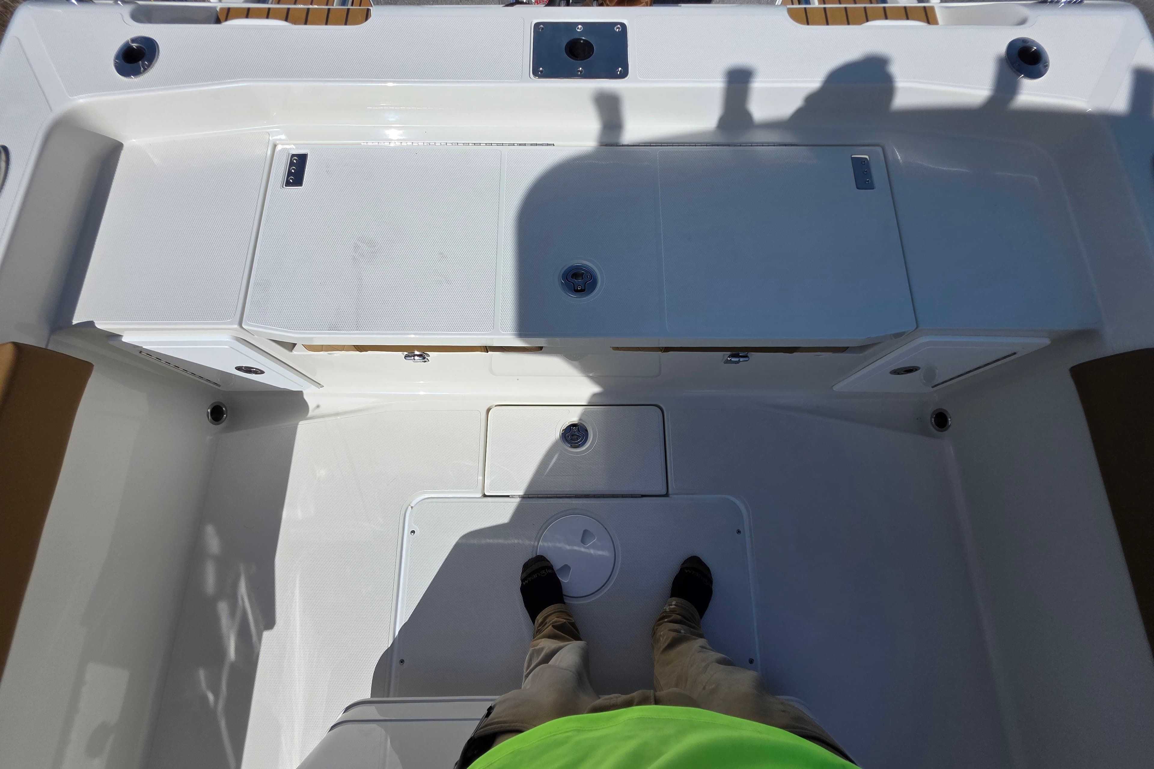 2026 Ranger 2660 Bay boat deck with storage compartments and person standing.