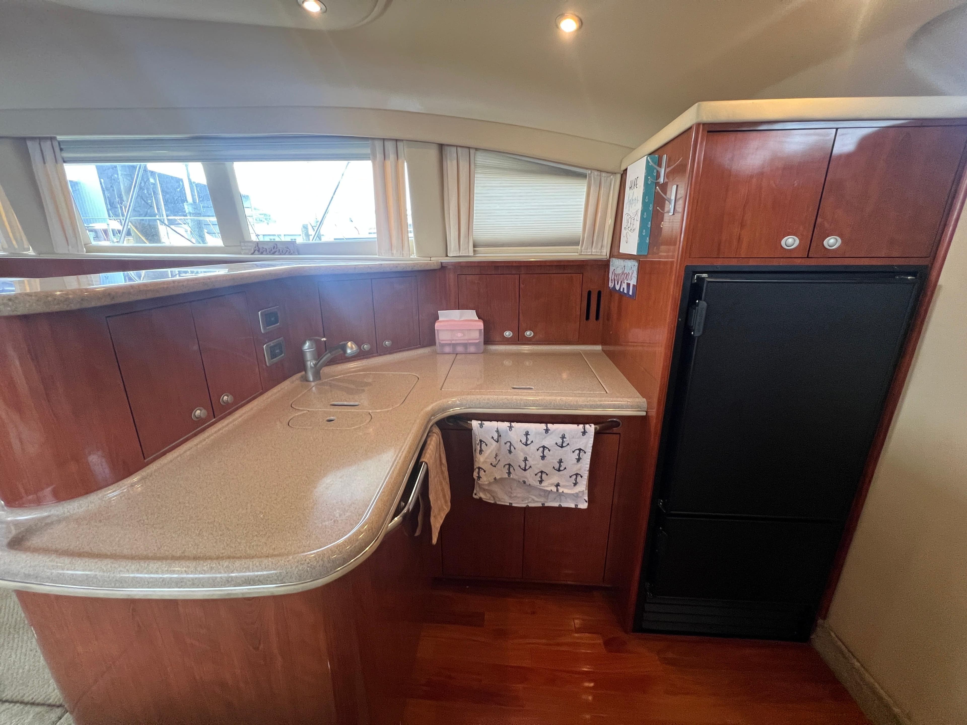 Luxurious 2004 Sea Ray 480 Motor Yacht kitchen with sleek wood cabinetry and modern appliances.
