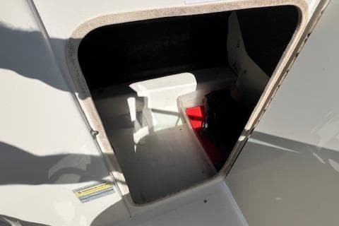 2004 Sea Ray 220 Sundeck storage compartment with open hatch, showing interior space.