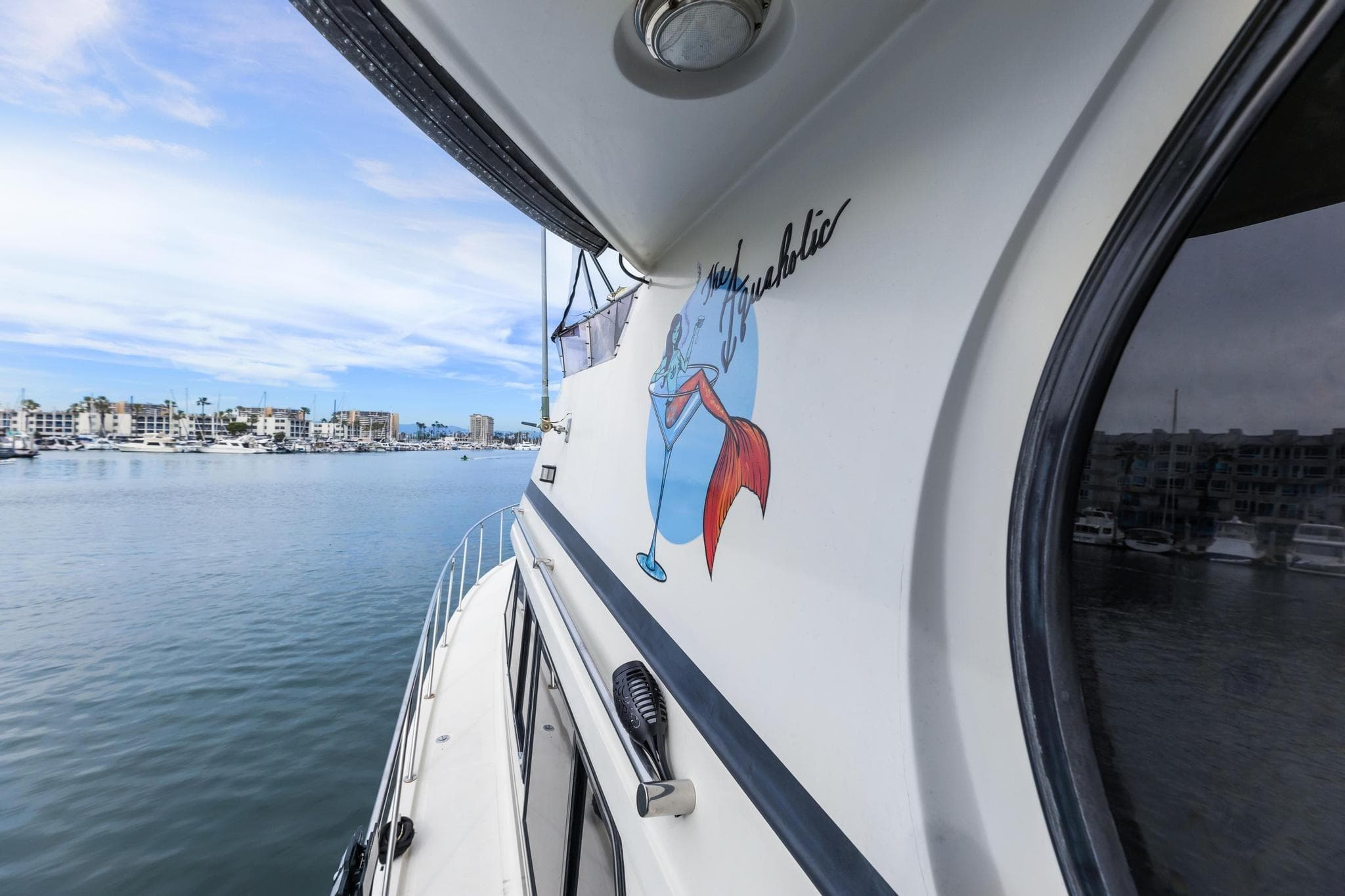 1988 Marine Trader Trawler on calm water, featuring a colorful mermaid graphic.