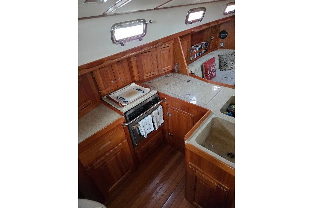 2009 Tartan 4300 yacht interior with wooden cabinetry, compact kitchen, and cozy seating area.