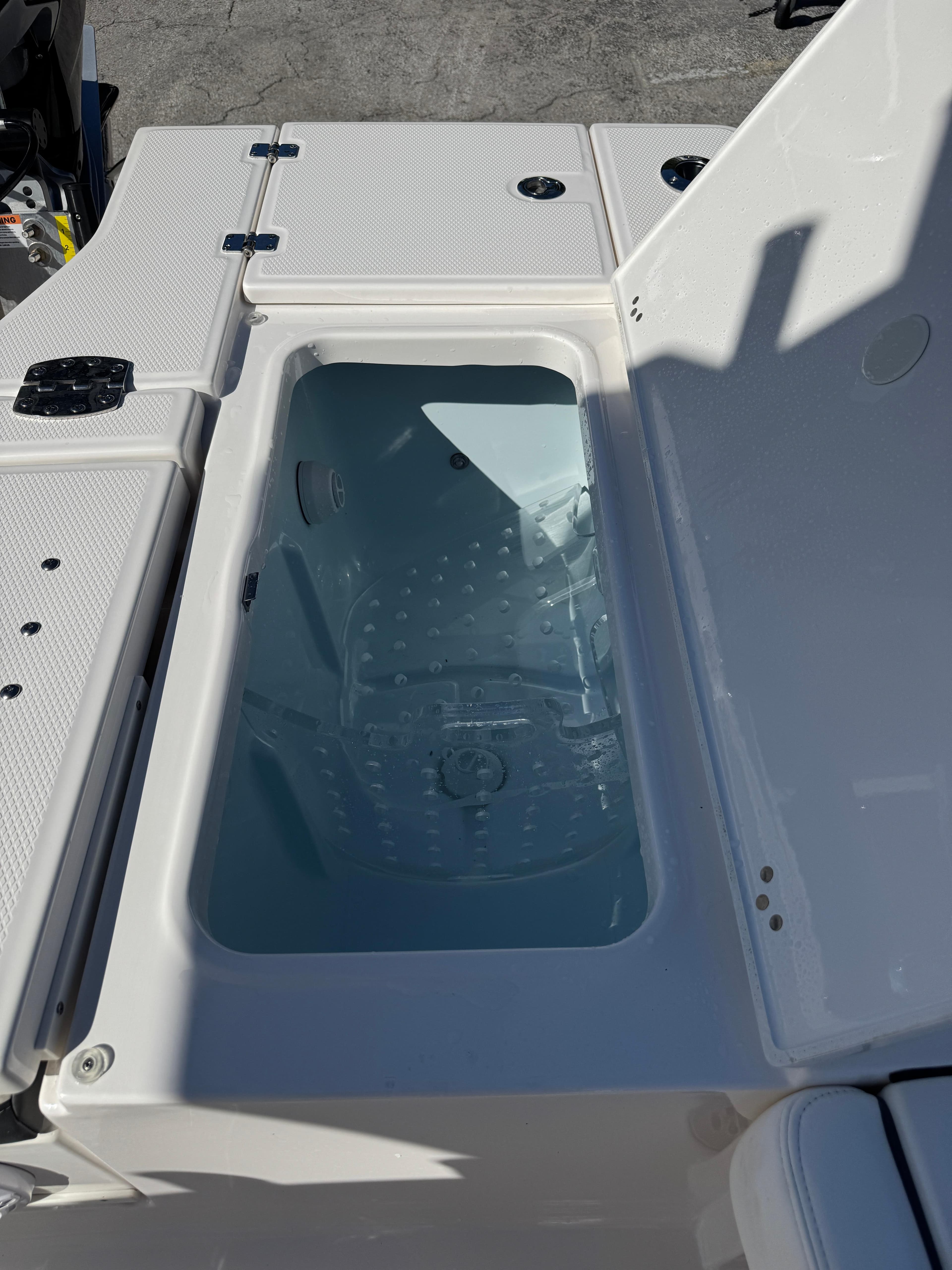 2024 Robalo 246 Cayman boat livewell with open lid, showcasing interior design.