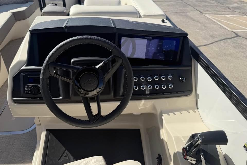 2026 Alera M 25Q boat dashboard with steering wheel and control panel.