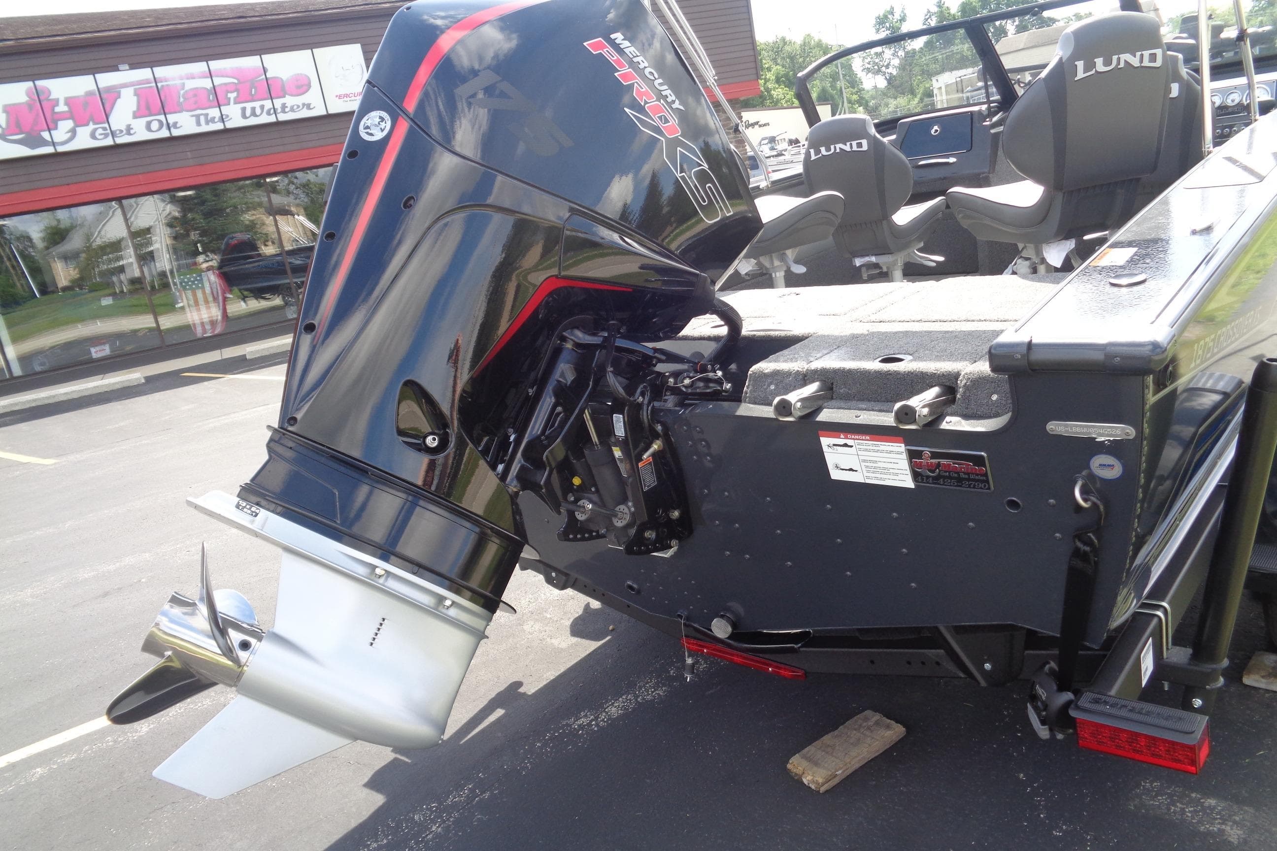 2026 Lund 1875 Crossover XS boat with powerful outboard motor at dealership.