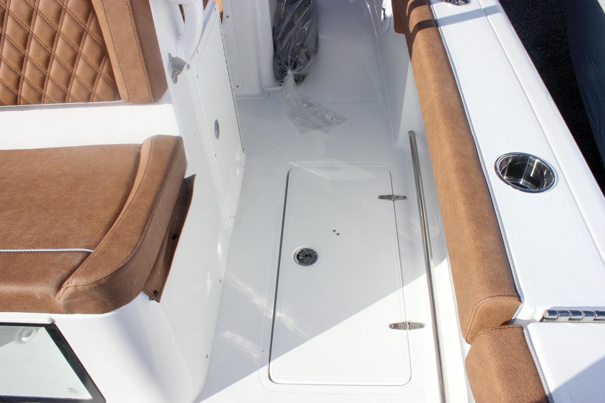 2026 Sea Hunt Ultra 285 SE boat interior with brown cushioned seating and storage compartment.