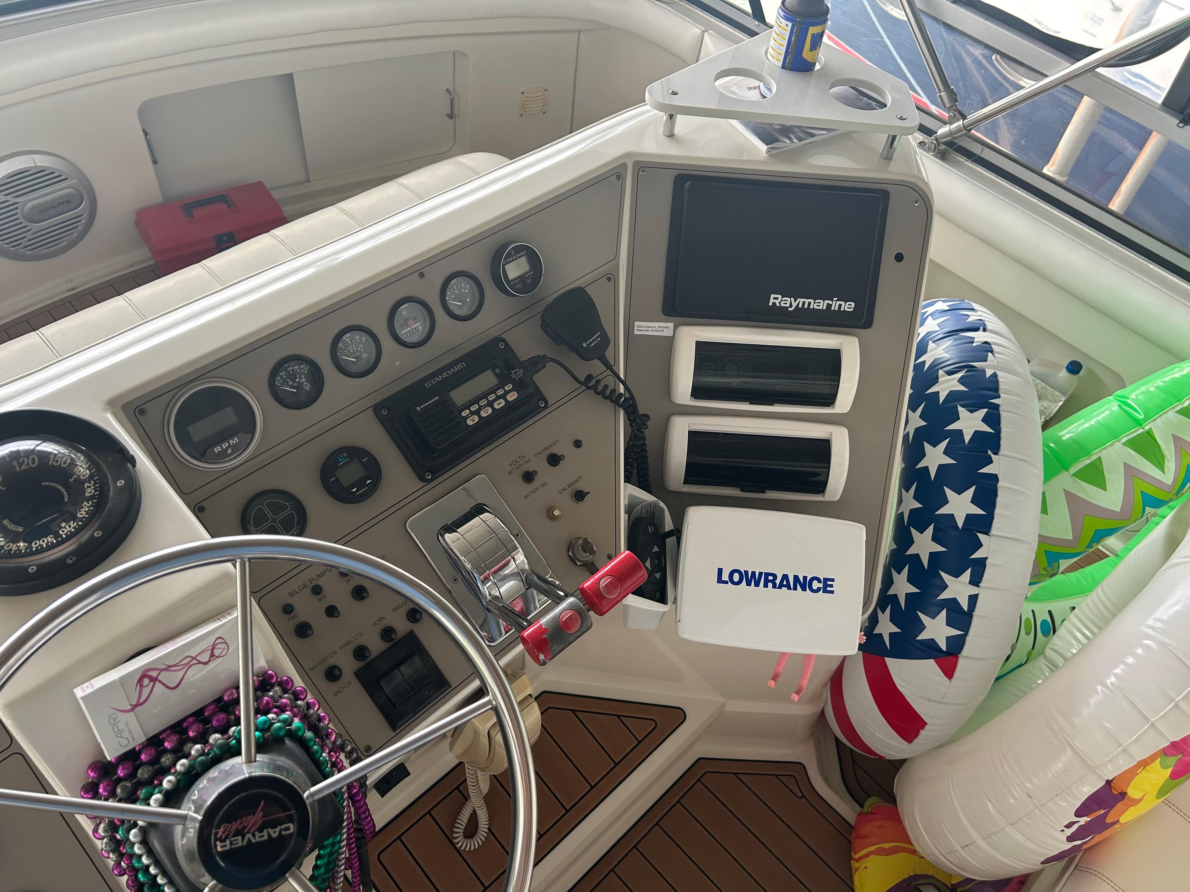 1996 Carver 440 Aft Cabin Motor Yacht helm with navigation equipment and colorful inflatables.