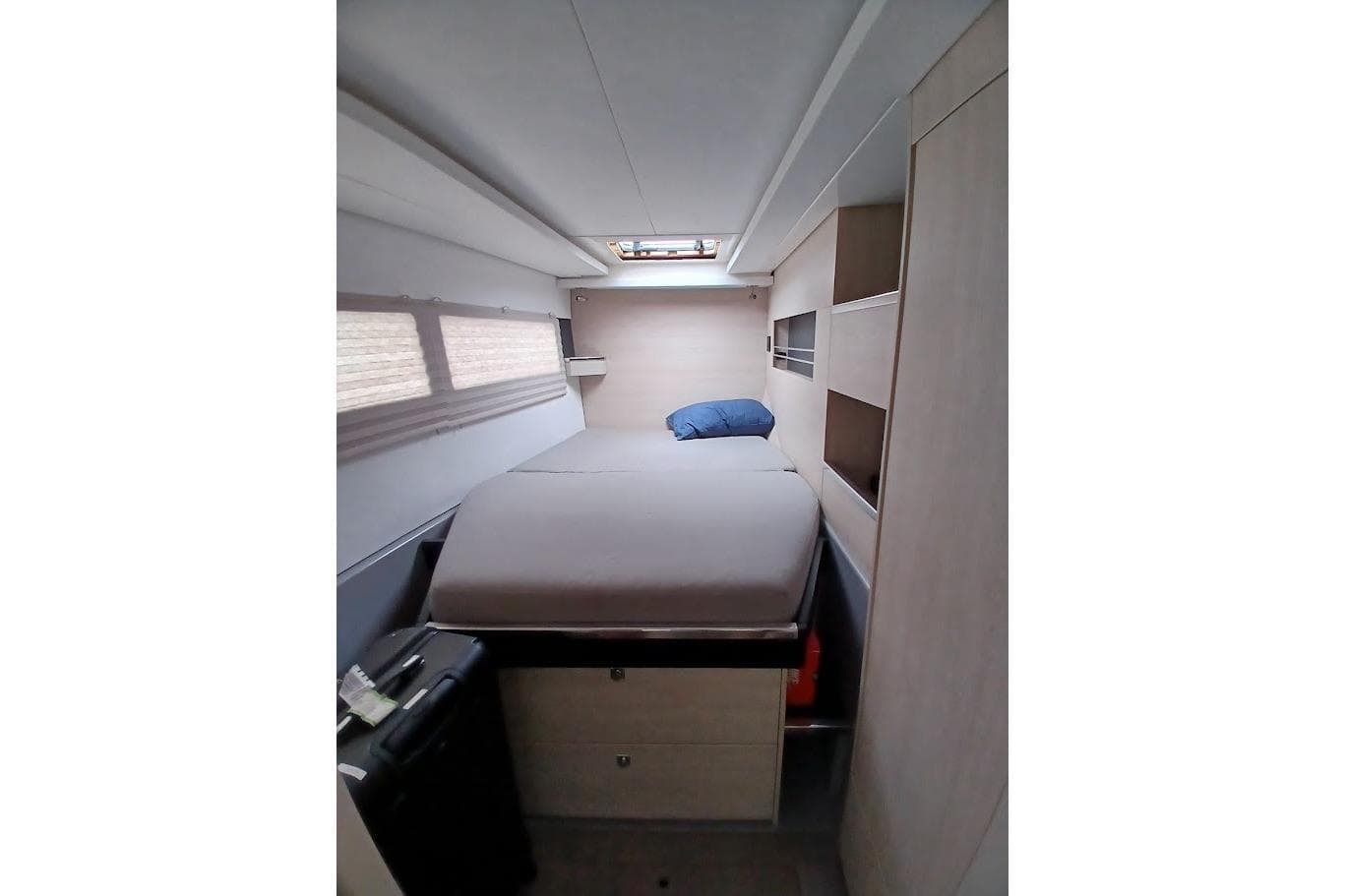 Interior cabin of a 2019 Leopard 45 yacht, featuring a cozy bed and storage space.