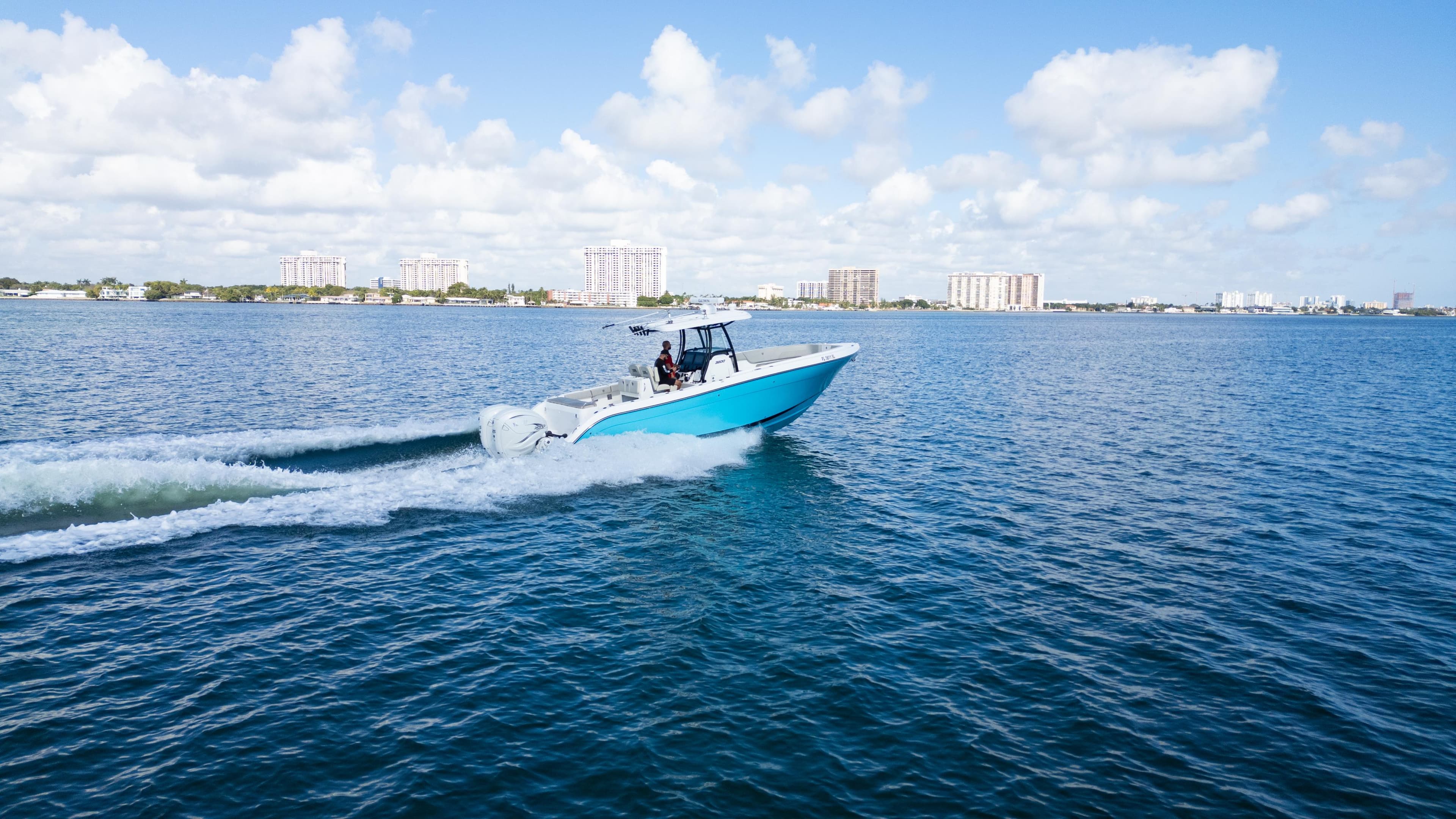 2019 Century 3200 Center Console boat cruising on open water under a clear blue sky.
