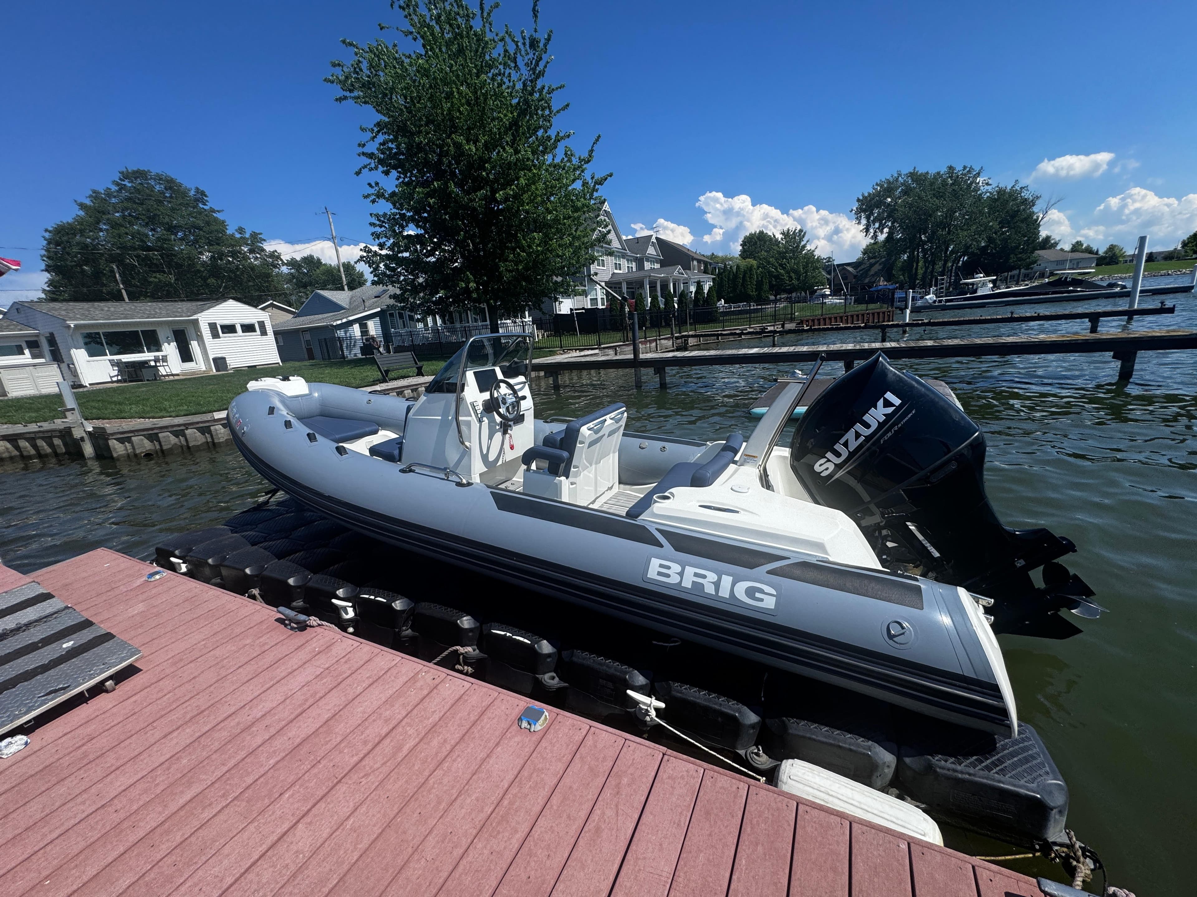 2022 Brig Eagle 6 boat docked by a lakeside with Suzuki outboard motor.