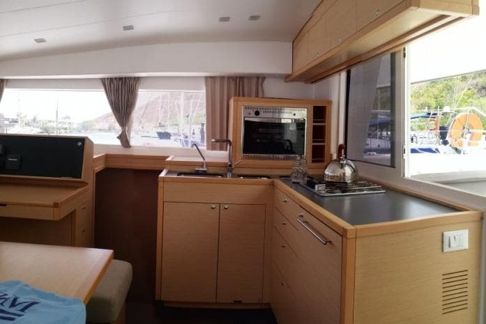 Interior of 2018 Lagoon L400s2 yacht kitchen with modern appliances and wood cabinetry.