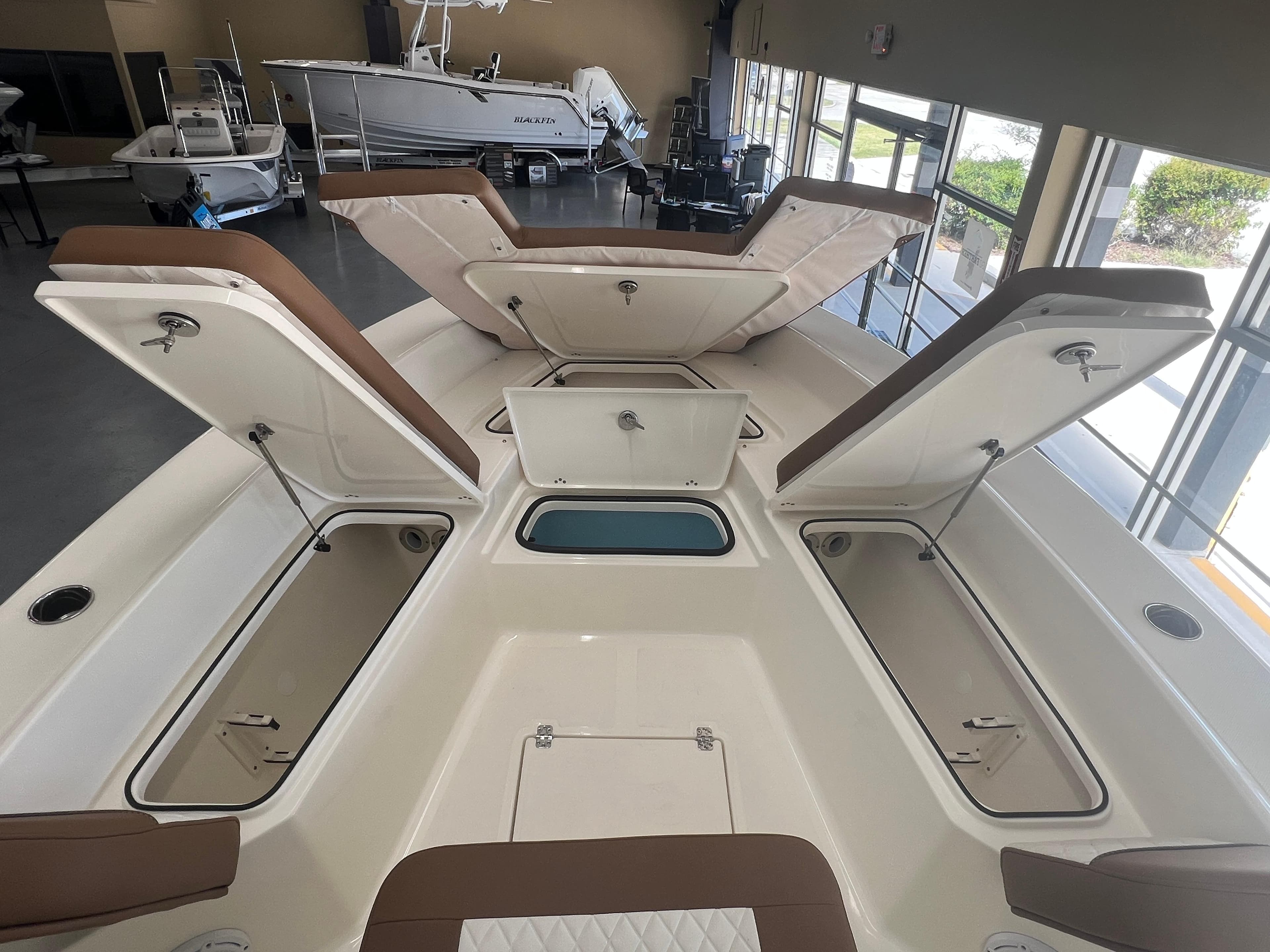 2026 Pioneer 220 Bay Sport boat interior with open storage compartments in showroom.