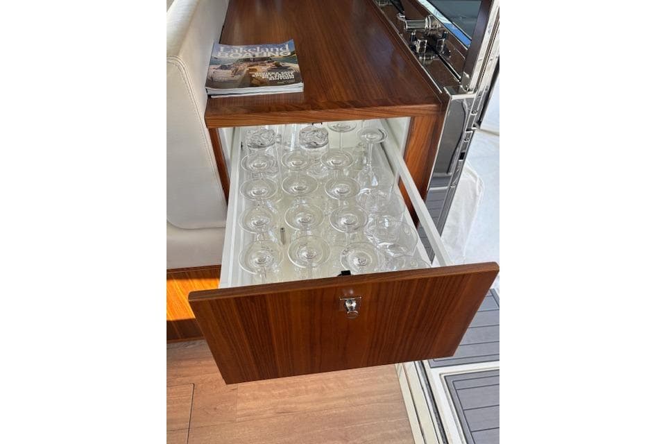 Wooden drawer with glassware in a 2020 Riviera 4800 Sport Yacht interior.