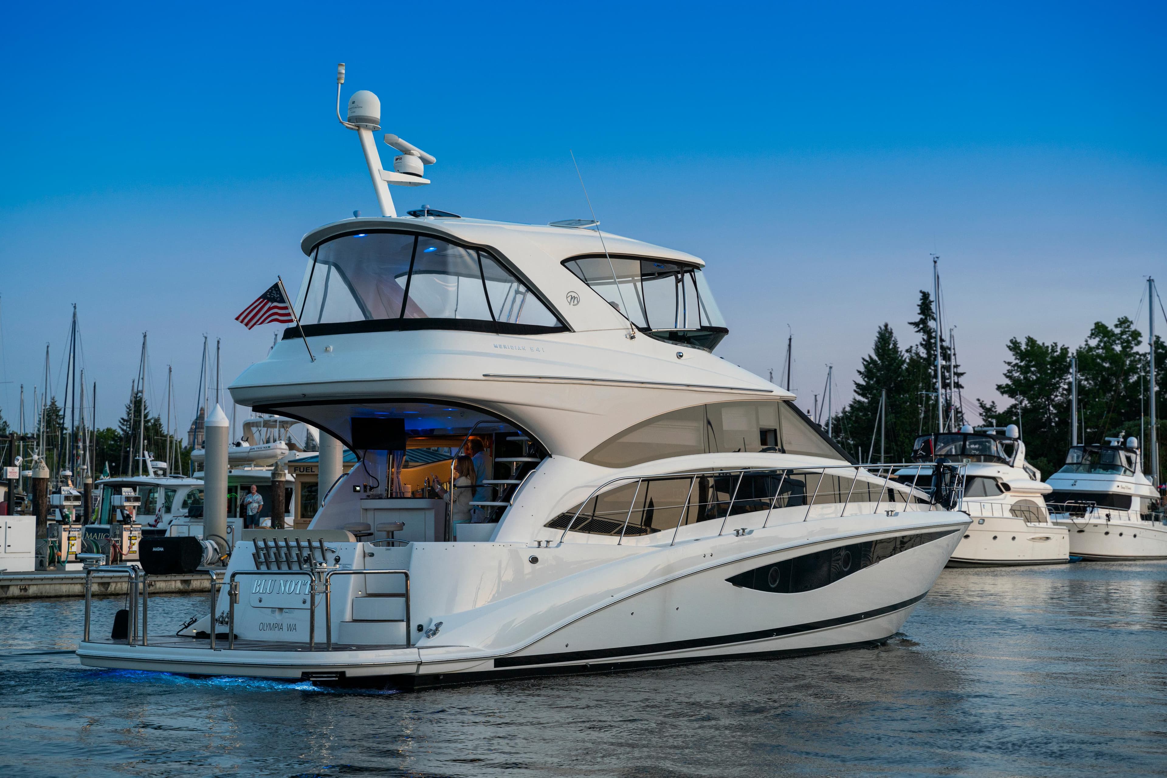 2012 Meridian 541 Sedan yacht docked at marina, clear blue sky.