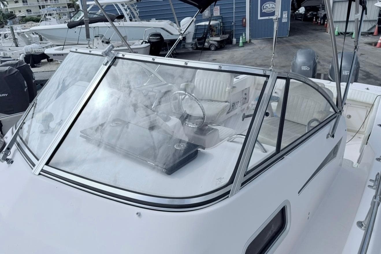 2005 Grady-White Journey 258 boat with windshield and steering wheel, docked at marina.
