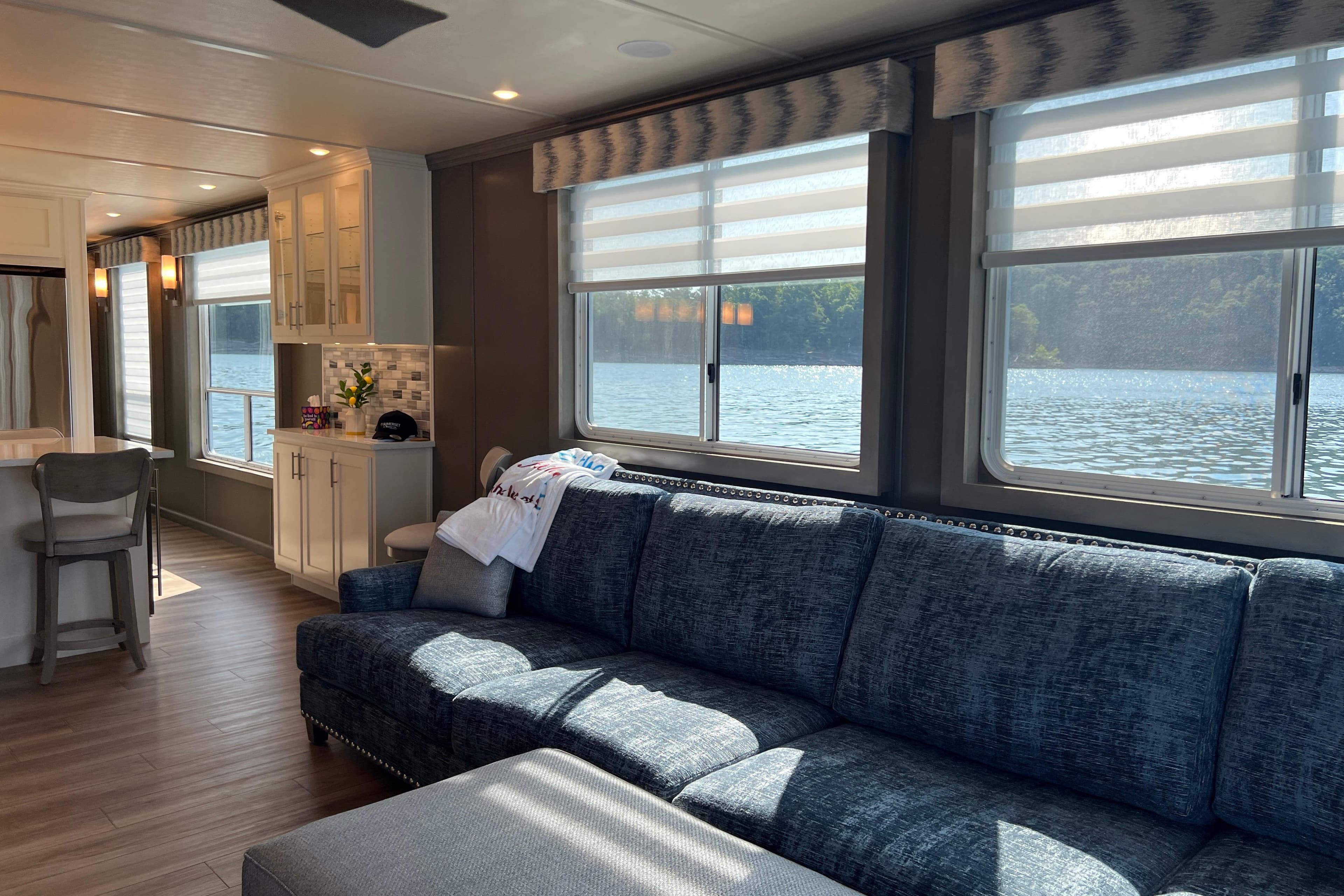 Luxurious Sumerset Luxe II 2026 houseboat interior with lake view, featuring modern kitchen and cozy seating.