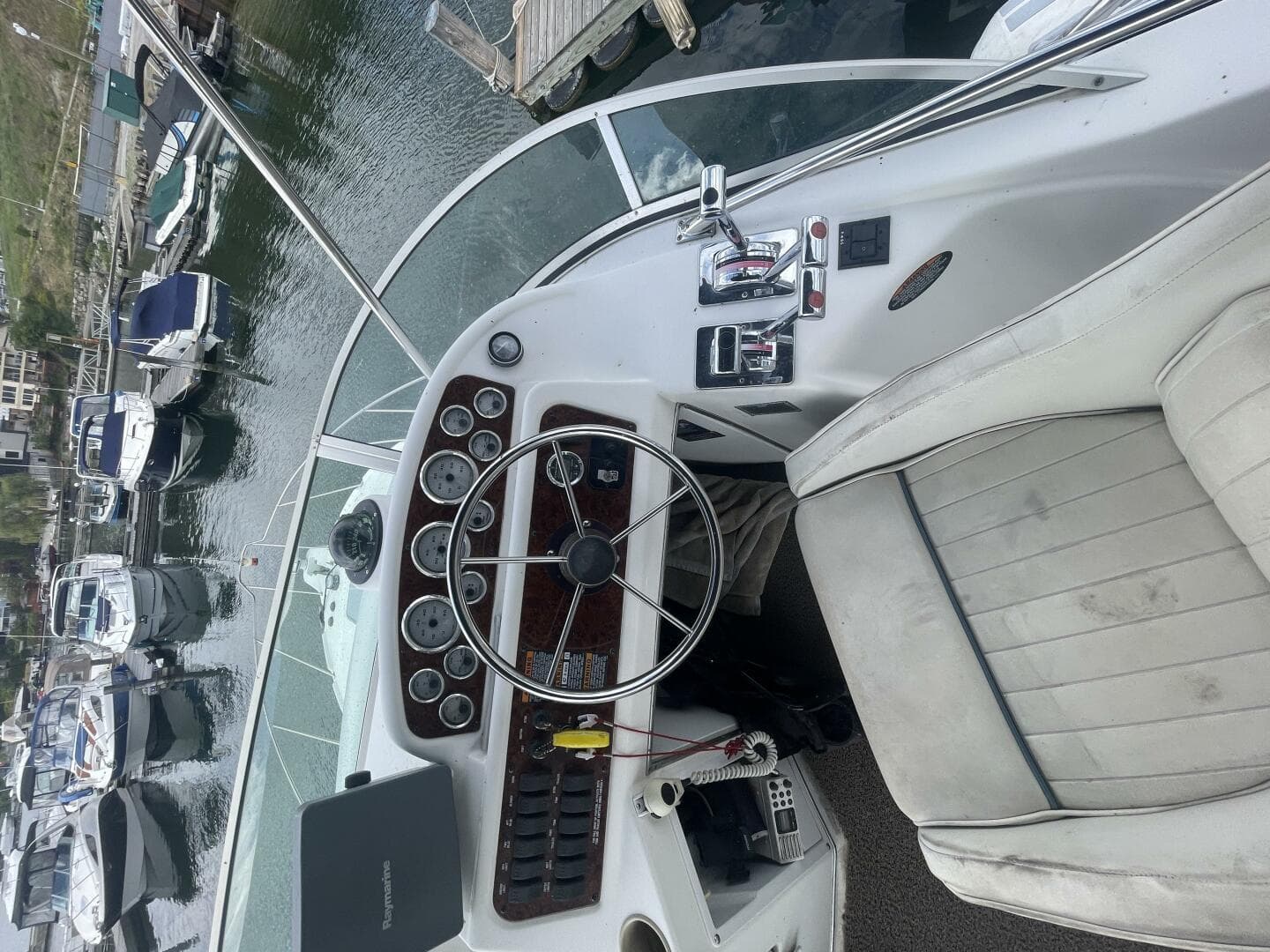 2001 Bayliner 3258 Ciera Command Bridge helm with controls and gauges, docked at marina.