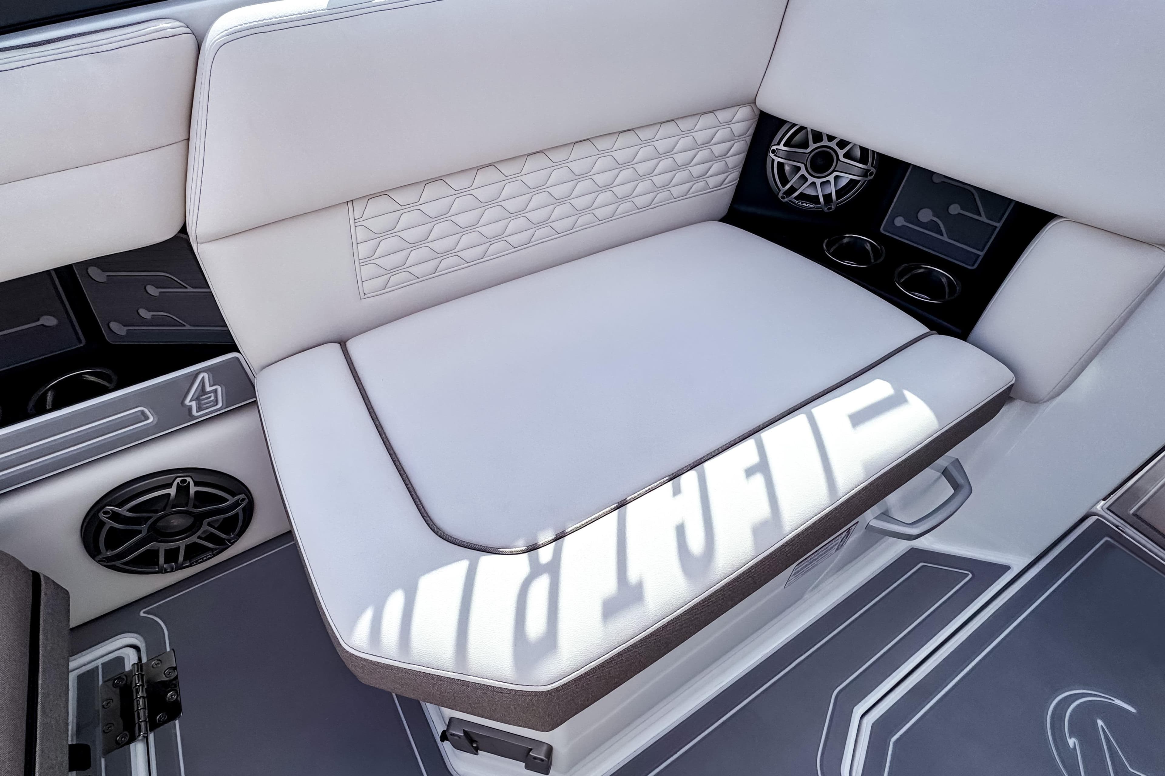2026 Ingenity EL boat interior with white cushioned seating and integrated speakers.