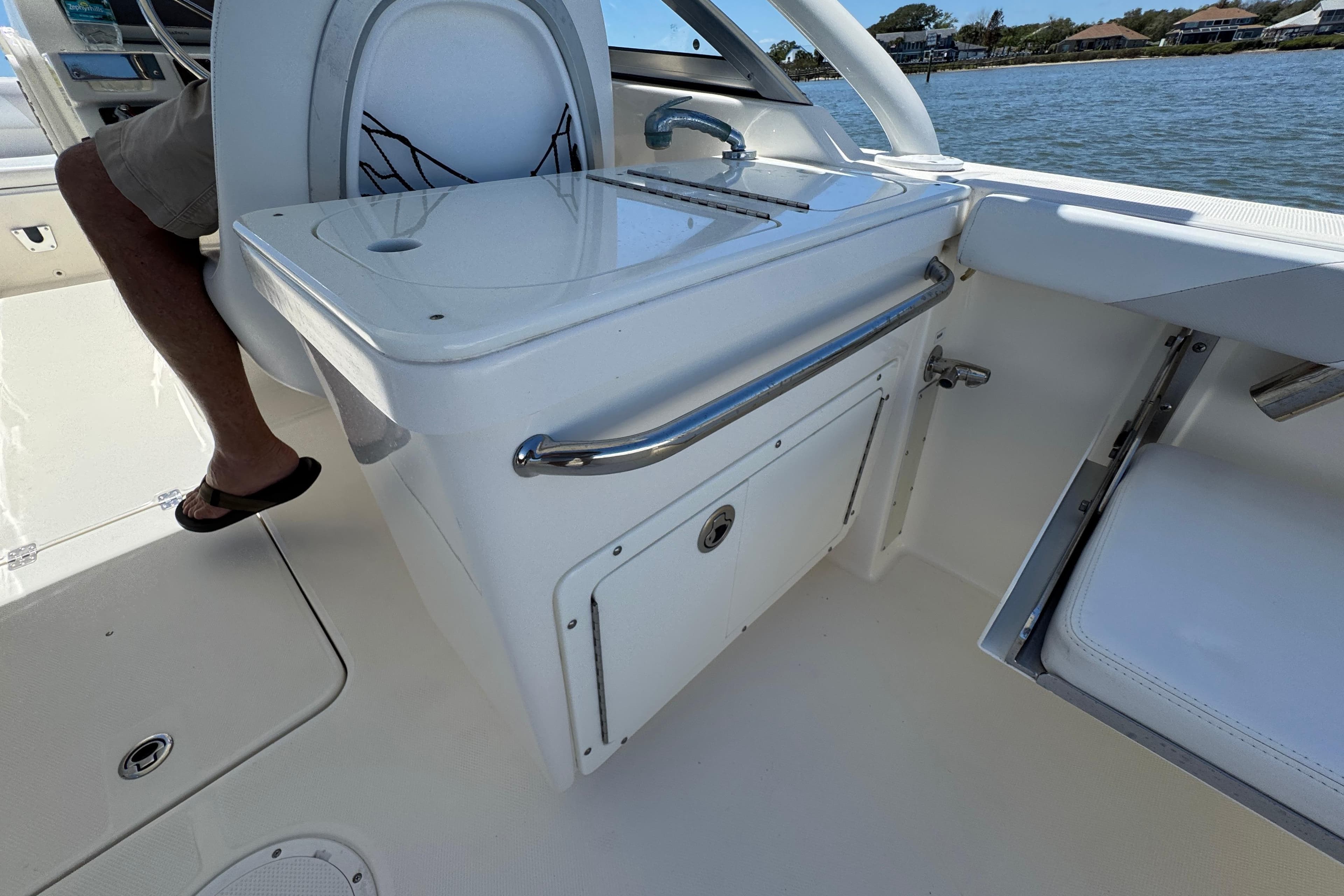 2012 Edgewater 245CX Crossover boat interior with seating and storage, near water.