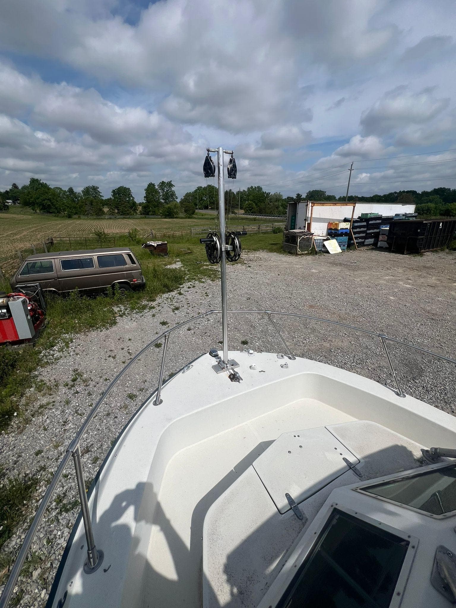 1988 Grady-White Offshore 240 boat on gravel, rural background with cloudy sky.