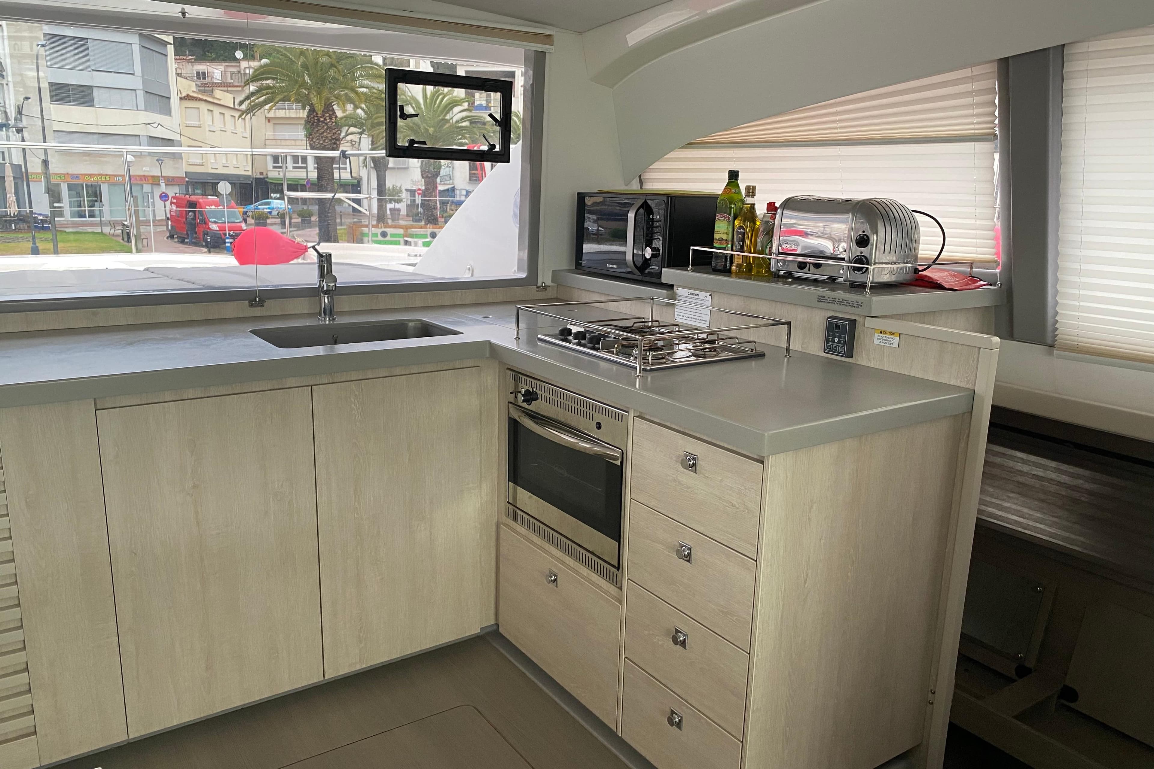 Modern kitchen interior of 2019 Leopard 43 Powercat yacht with appliances and large window view.