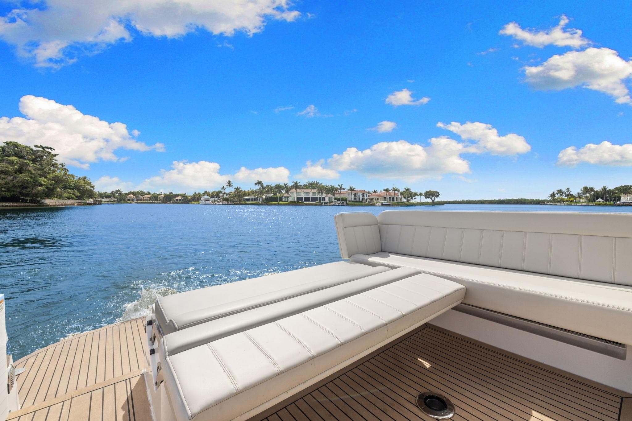 2024 MJM 42 yacht with luxurious seating, cruising on a serene blue lake.
