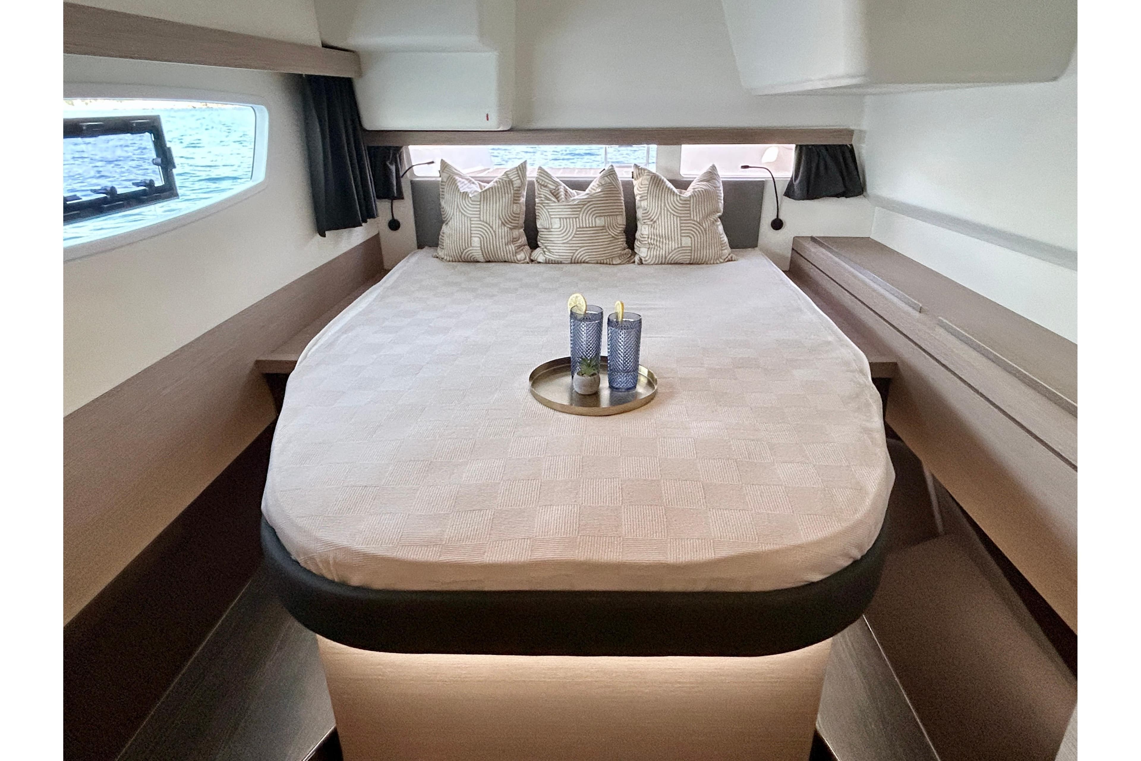 Luxurious bedroom interior of 2021 Fountaine Pajot Isla 40 catamaran with elegant bedding.