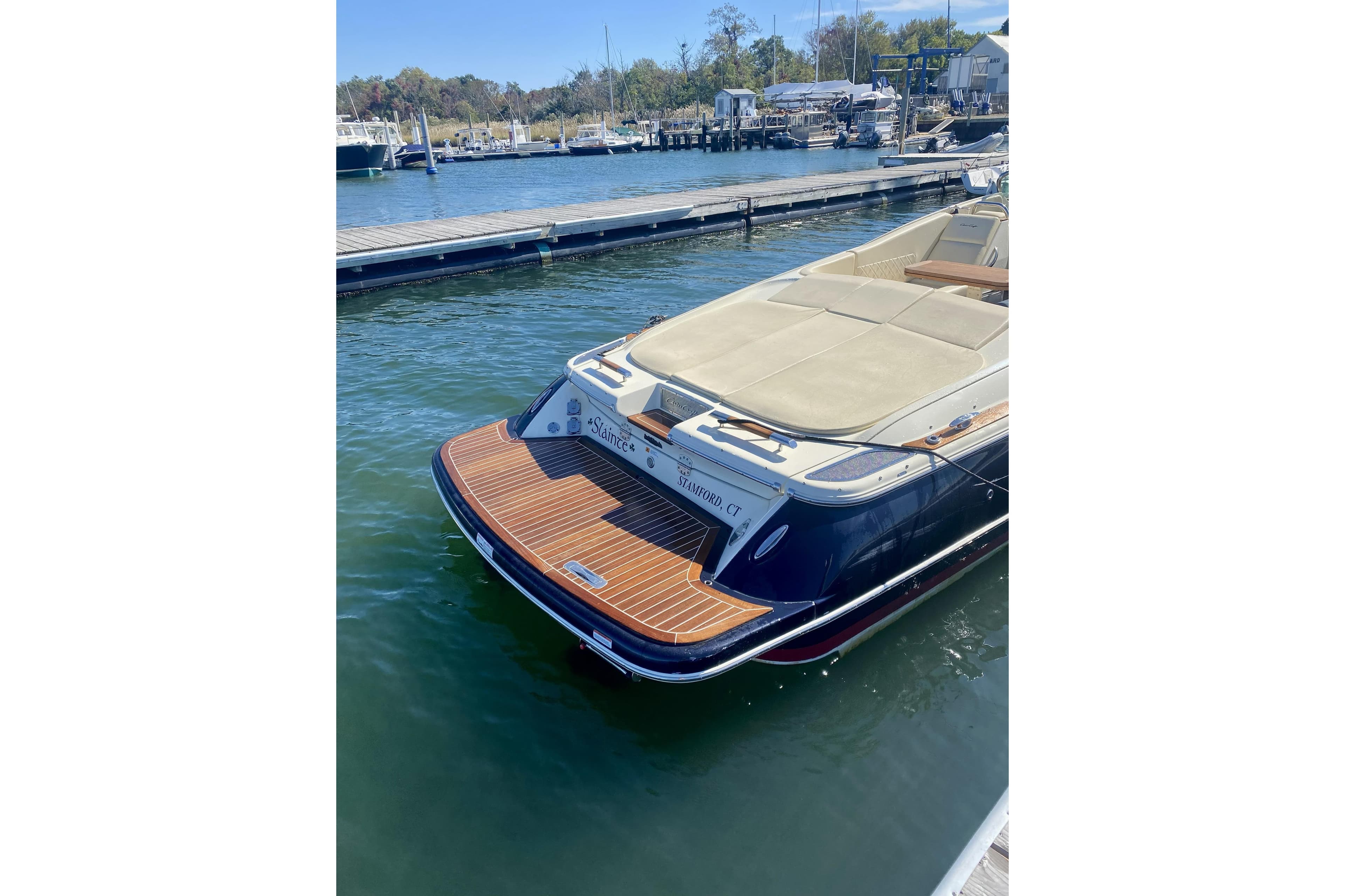 2016 Chris-Craft Corsair 32 docked at marina, showcasing elegant design and teak swim platform.