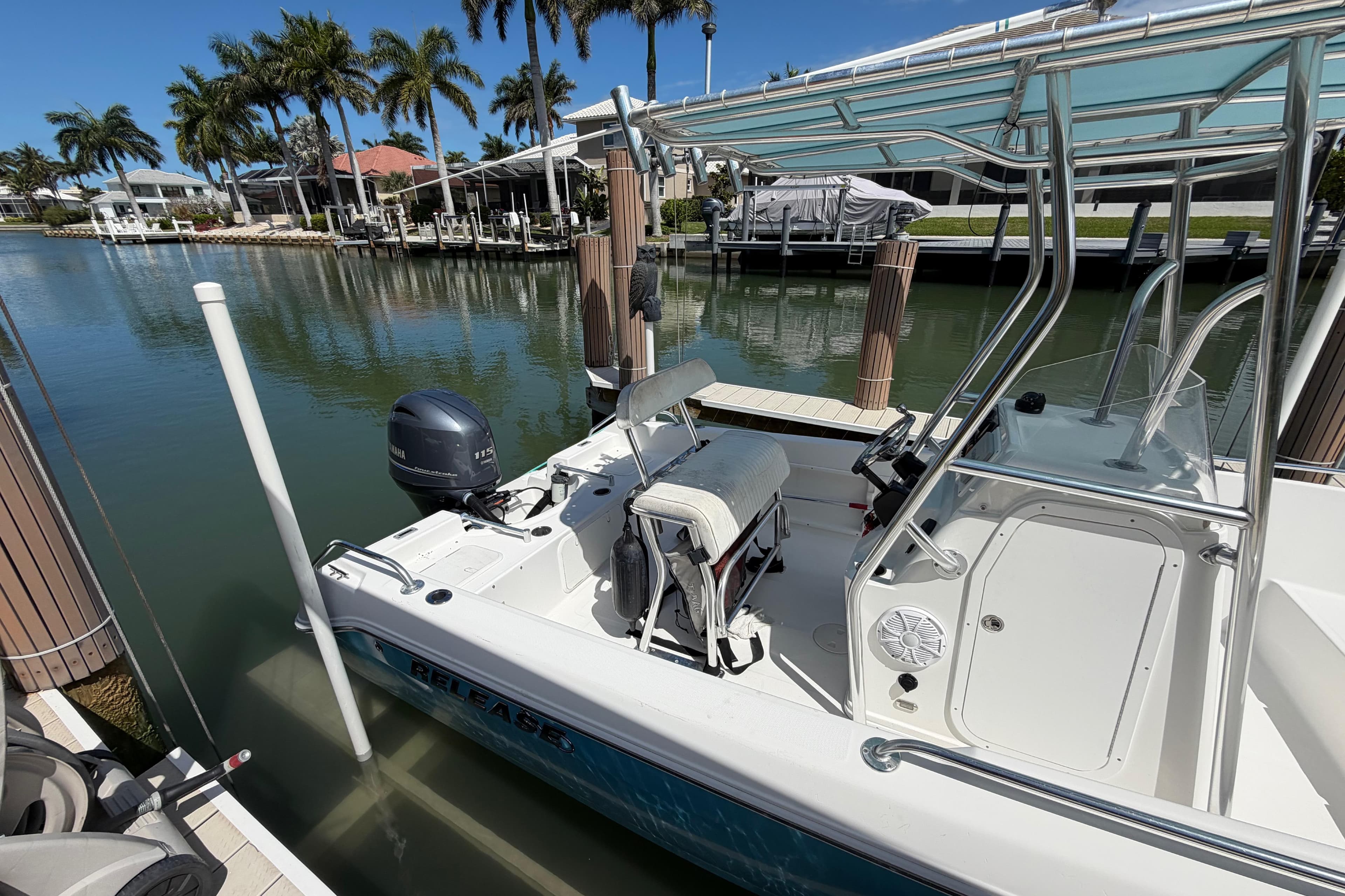 2017 Release 196 RX boat docked by palm trees and waterfront homes.