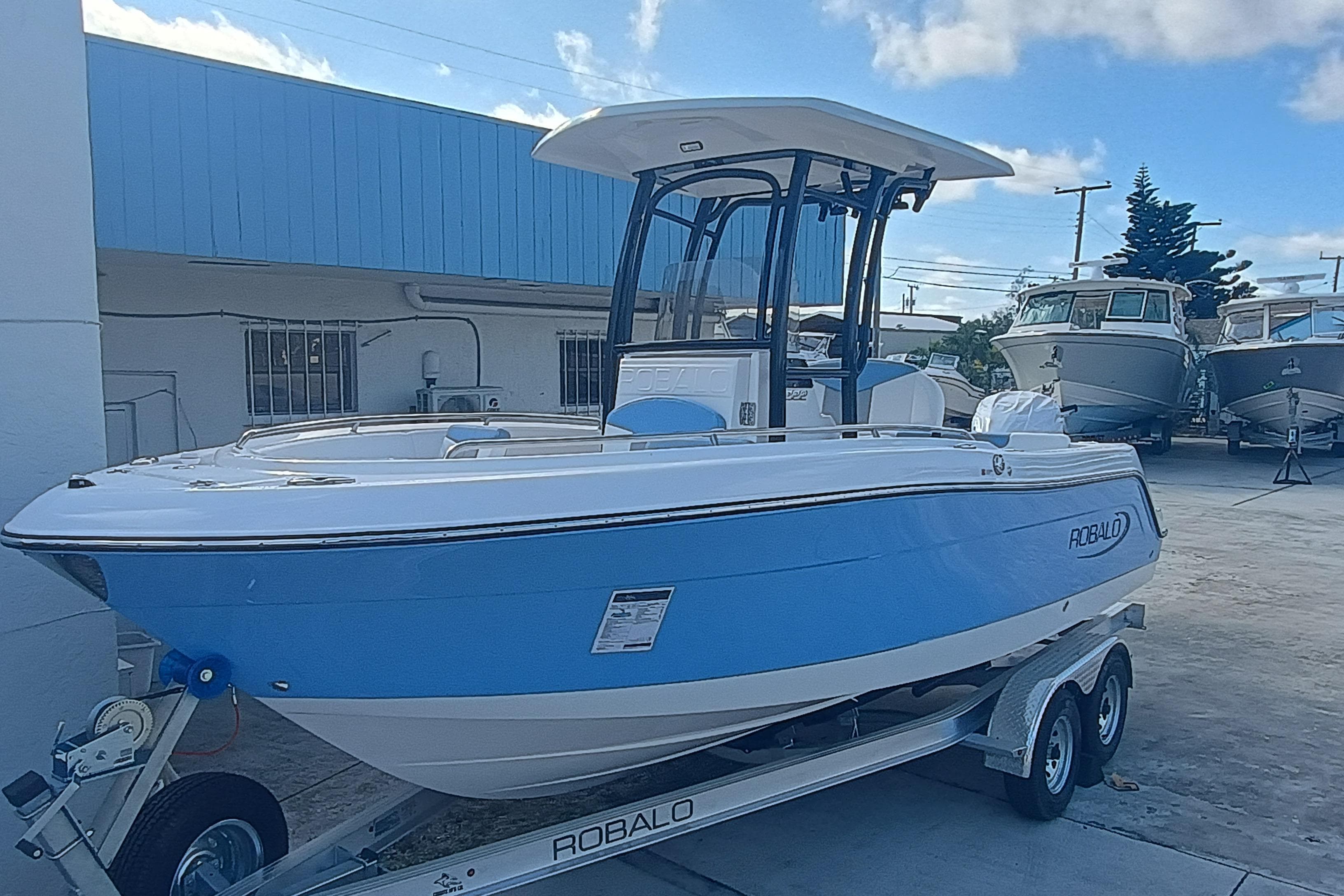 2026 Robalo R222 Center Console boat on trailer, blue and white design, outdoor display.