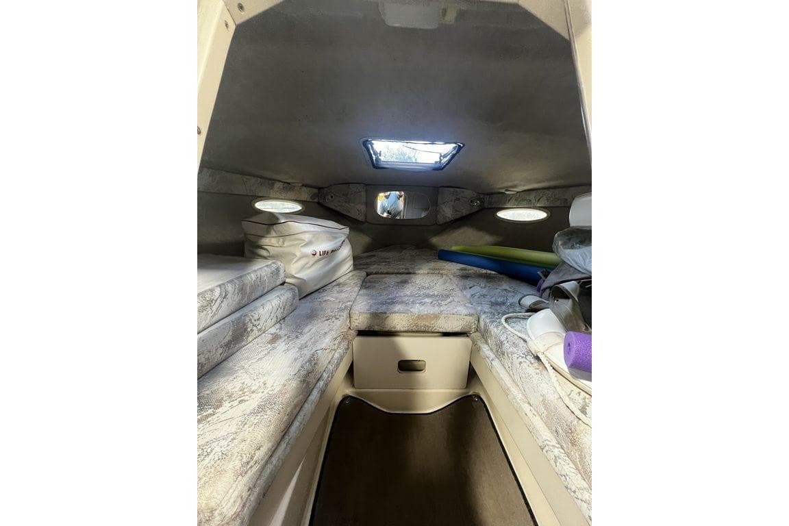 Interior cabin of 1994 Sea Ray 220 boat with cushioned seating and storage.