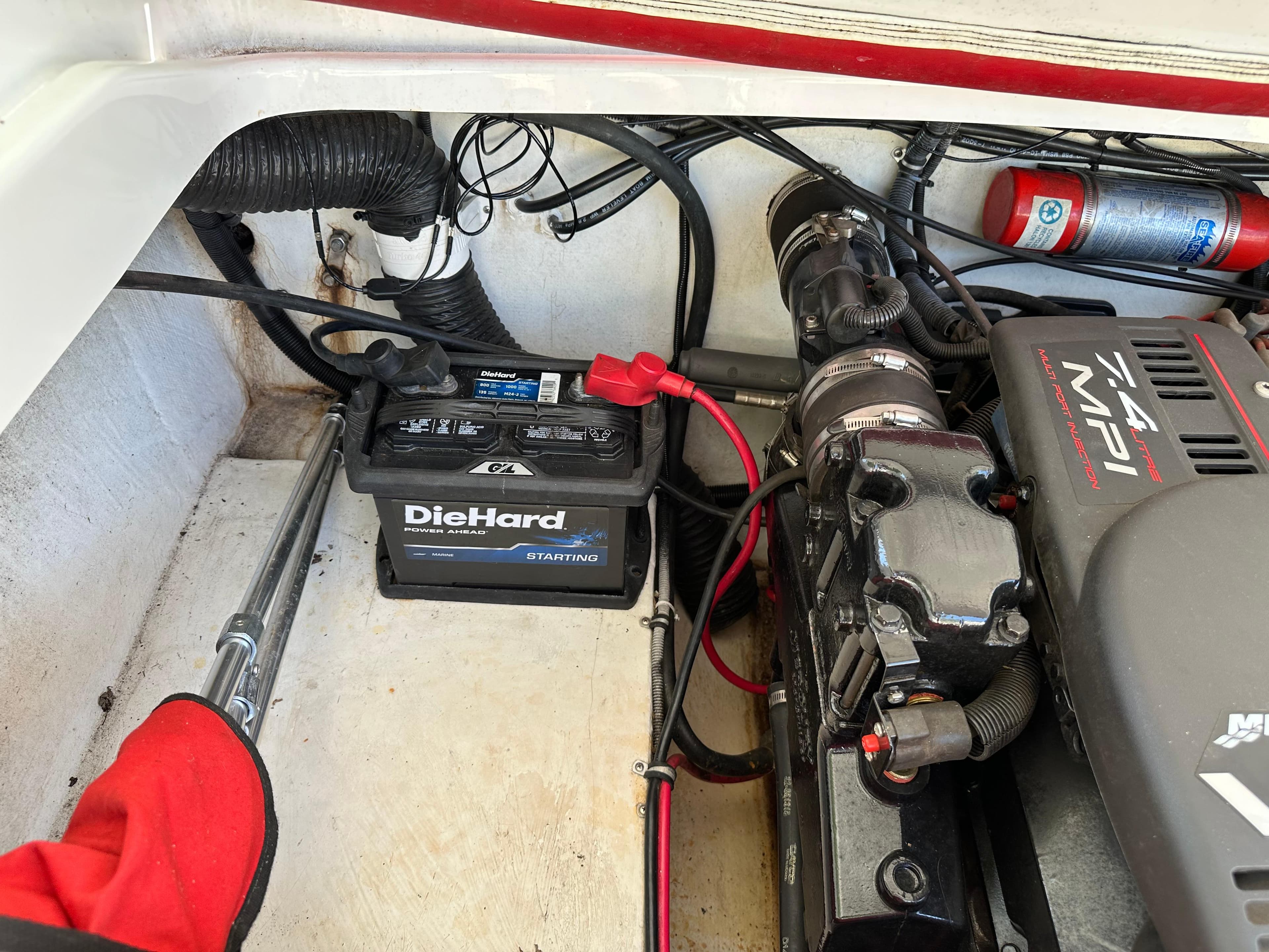Engine compartment of a 2001 Baja 232 boat with DieHard battery and fire extinguisher.