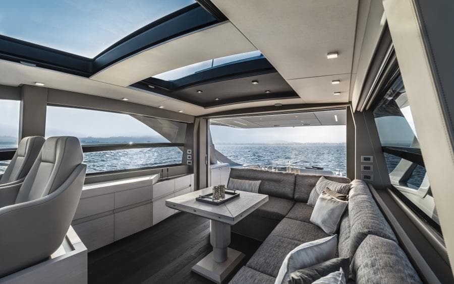 Luxurious interior of 2024 Pershing 7X yacht with ocean view and modern seating.