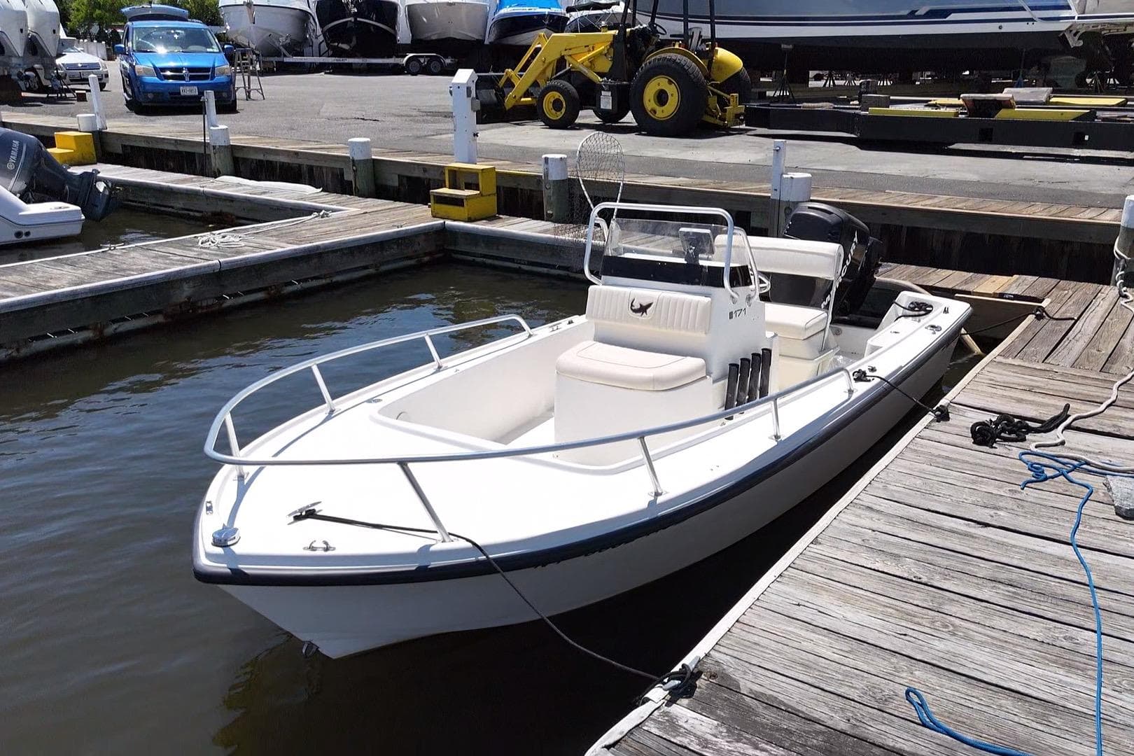 2006 Mako 171 Center Console boat docked at a marina, surrounded by other vessels.