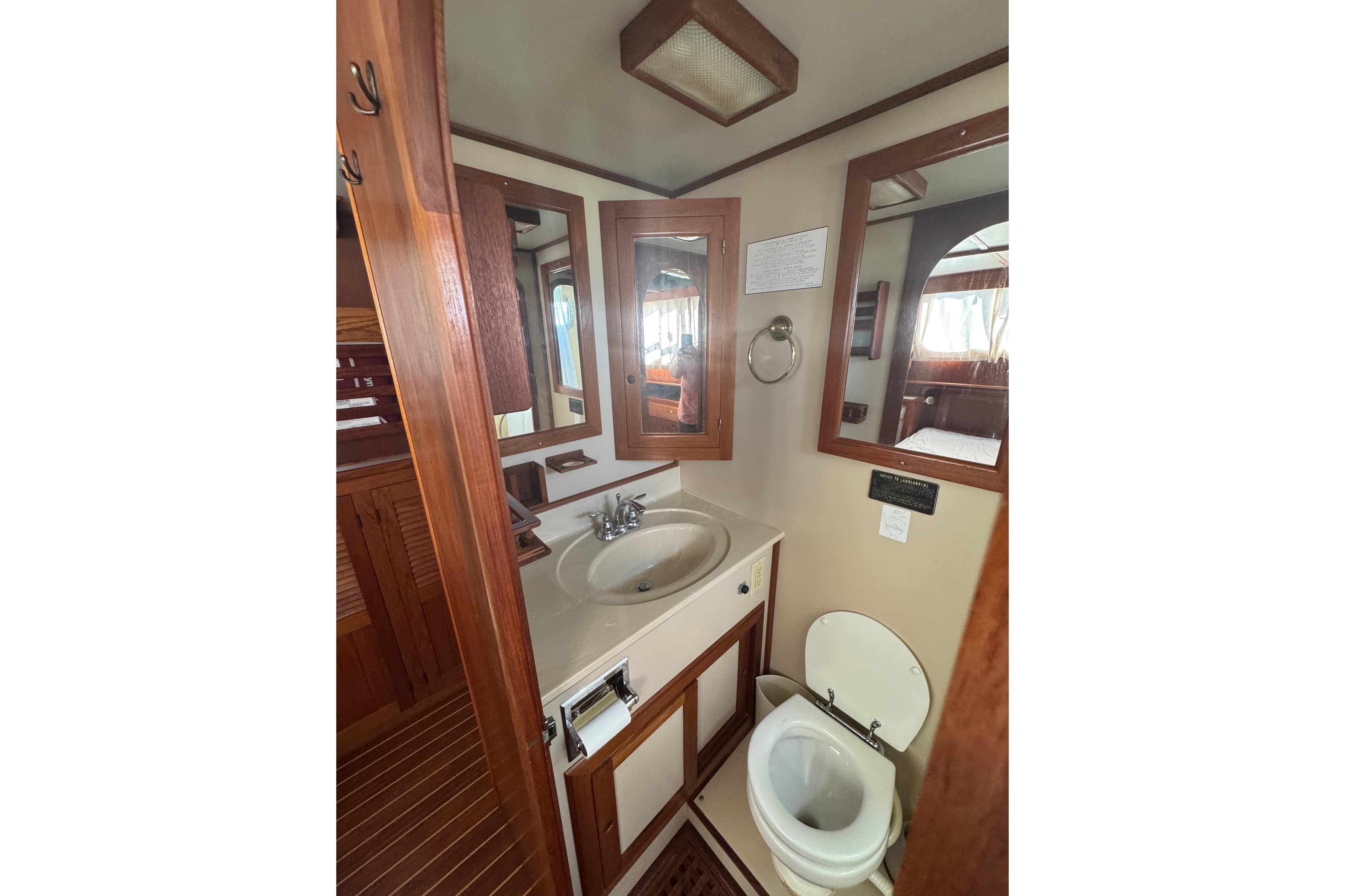 Bathroom interior of 2001 Monk Trawler with wooden accents and mirror.