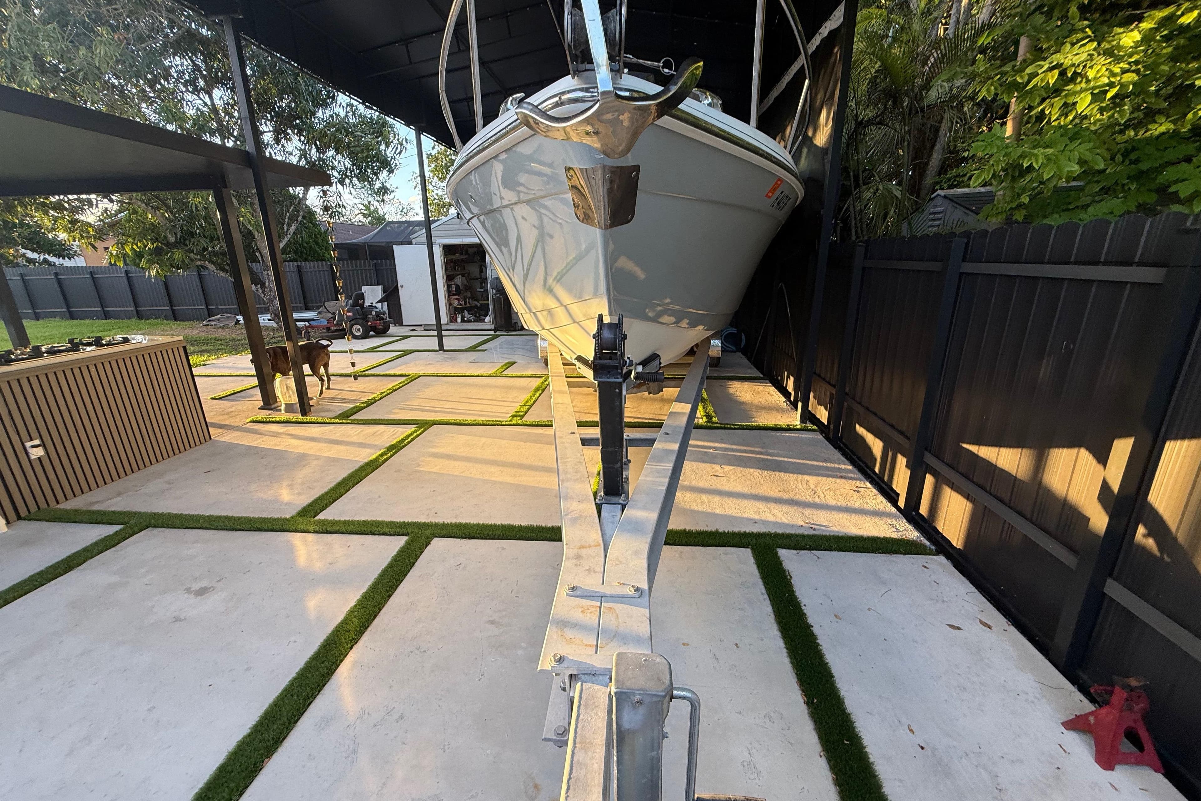 2005 Formula 330 Sun Sport boat on trailer in modern backyard setting.