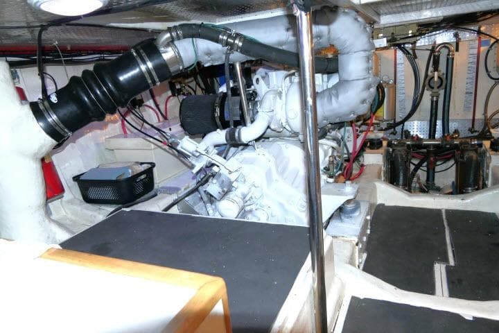 Engine room of a 1999 Hampton 490 Pilothouse yacht, showcasing mechanical components and wiring.