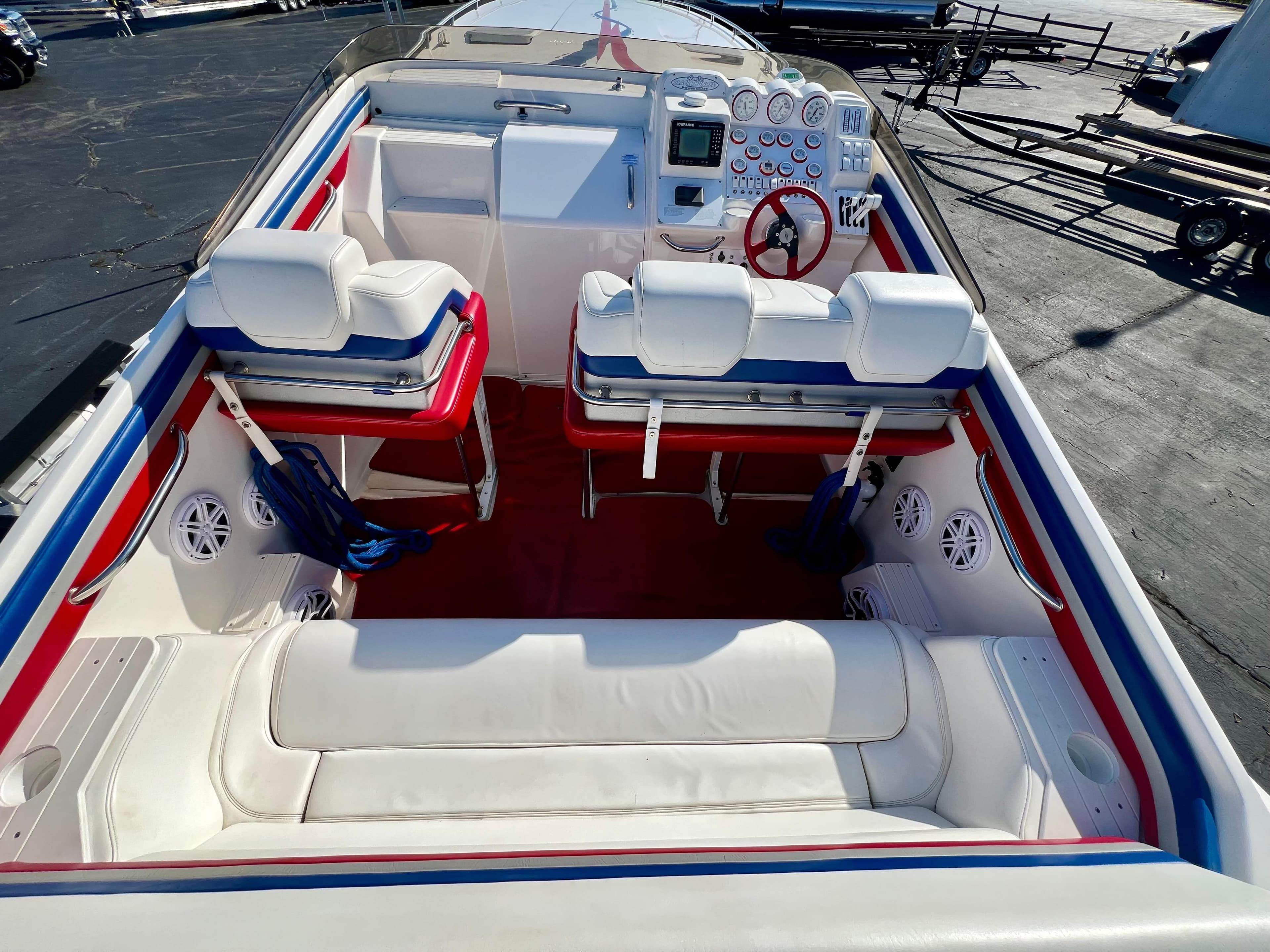 1999 Black Thunder 430 Flat Deck boat interior with white seating and red accents.