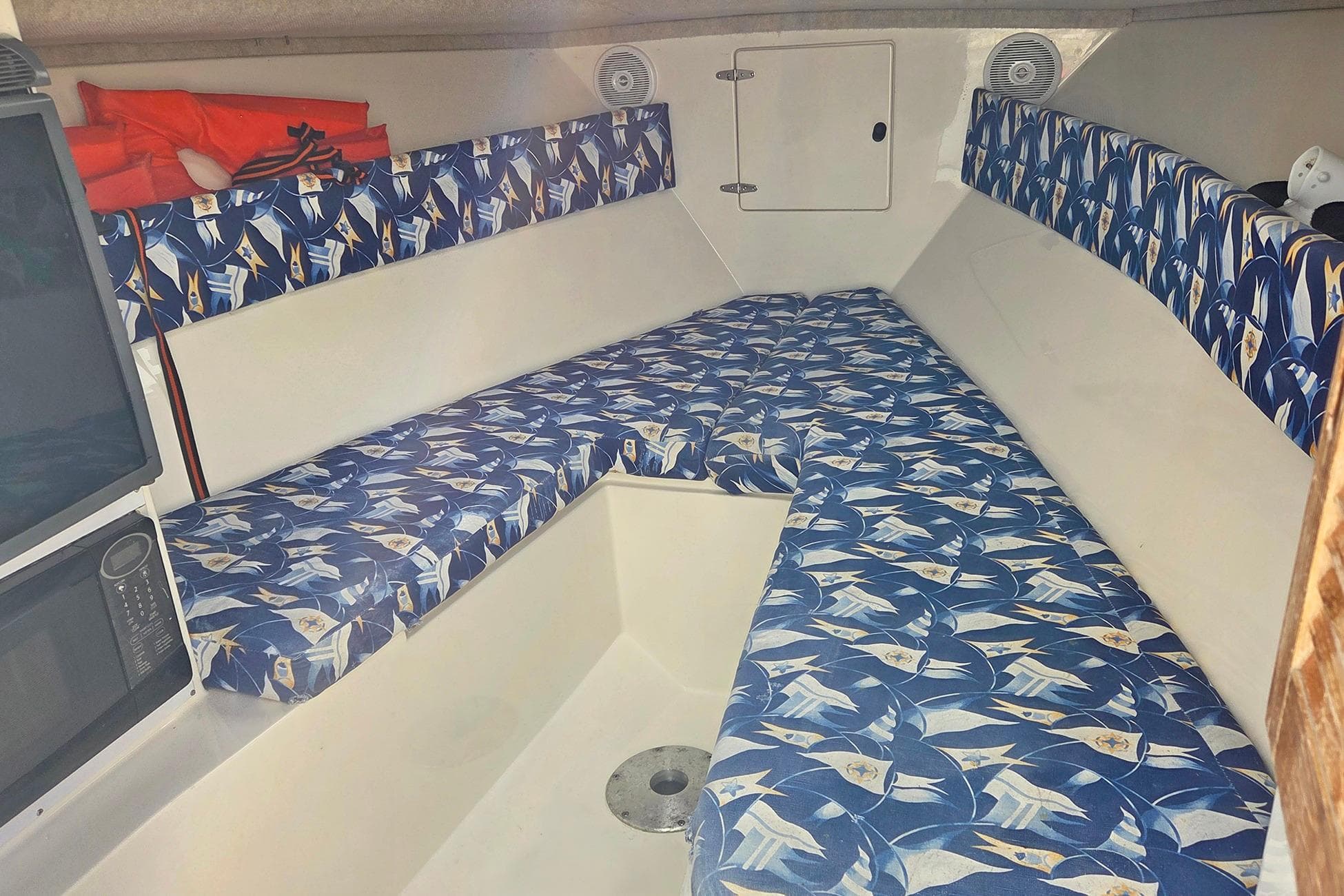 2001 Jupiter 31 Cuddy cabin interior with patterned cushions and storage space.