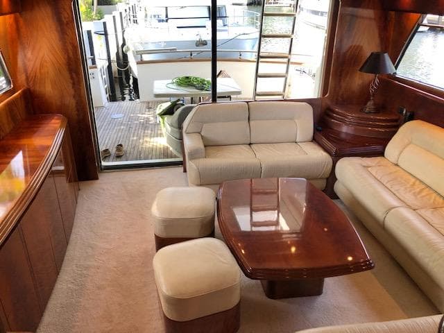 Luxurious interior of 2001 Maiora 20 yacht with plush seating and wooden accents.