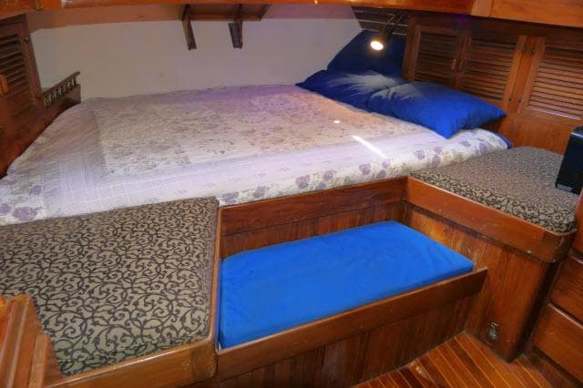 Cozy cabin interior of 1978 Brewer 45 Ketch with bed and wooden furnishings.
