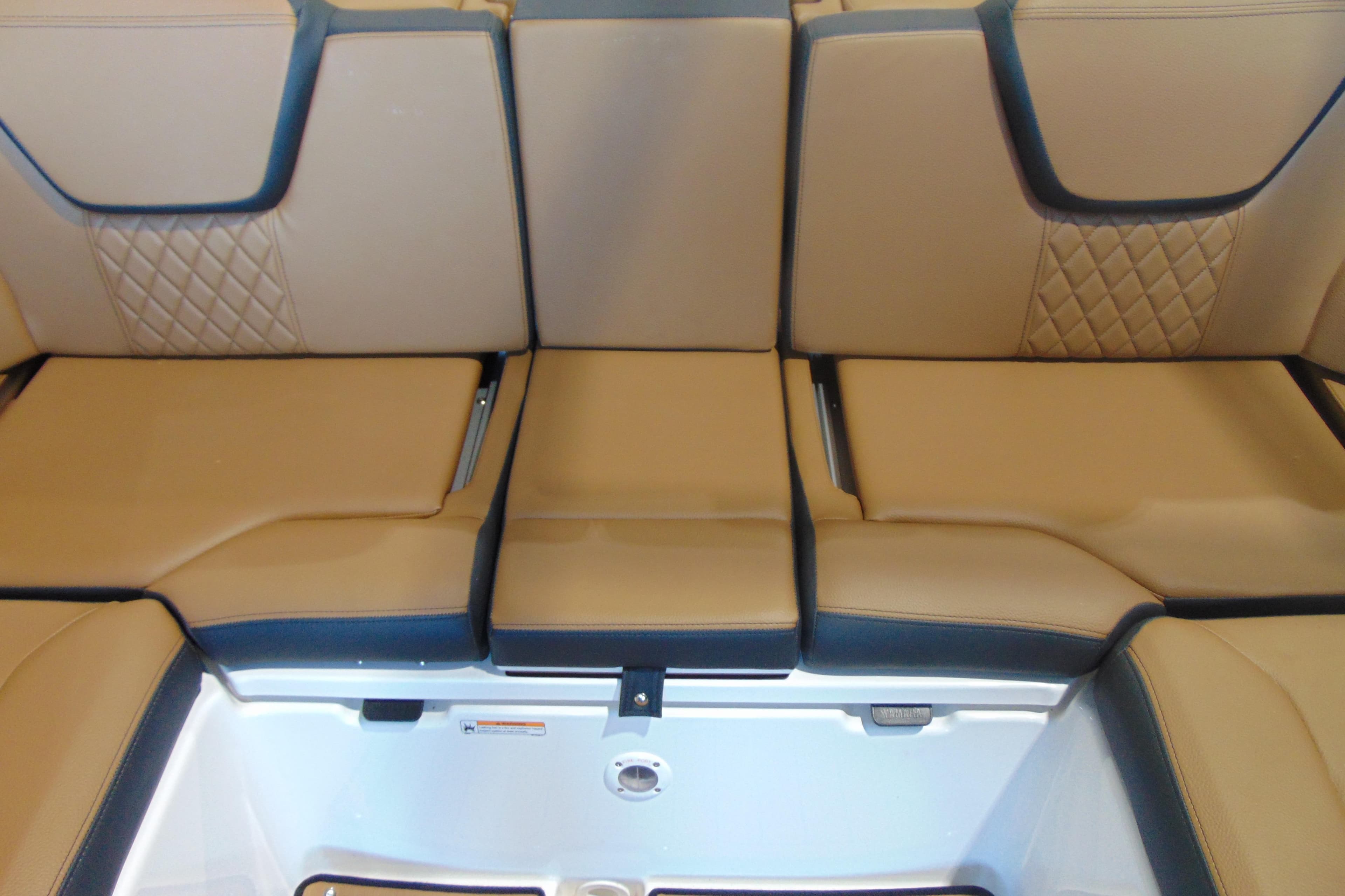 Luxurious tan seating on 2026 Yamaha Boats 252SD, featuring diamond stitching and storage compartment.