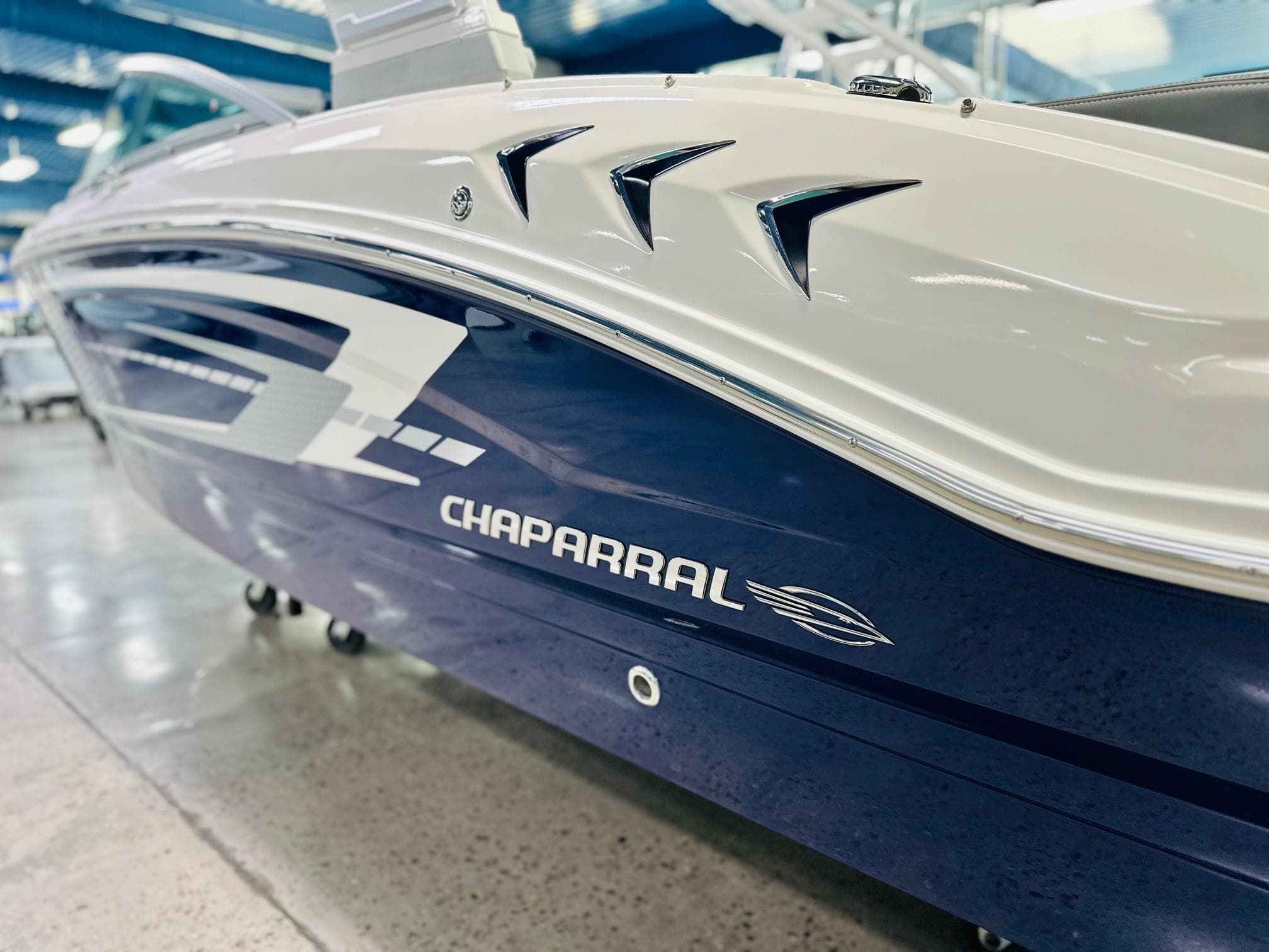 2025 Chaparral 21 SSi OB boat, sleek blue and white design, showroom display.